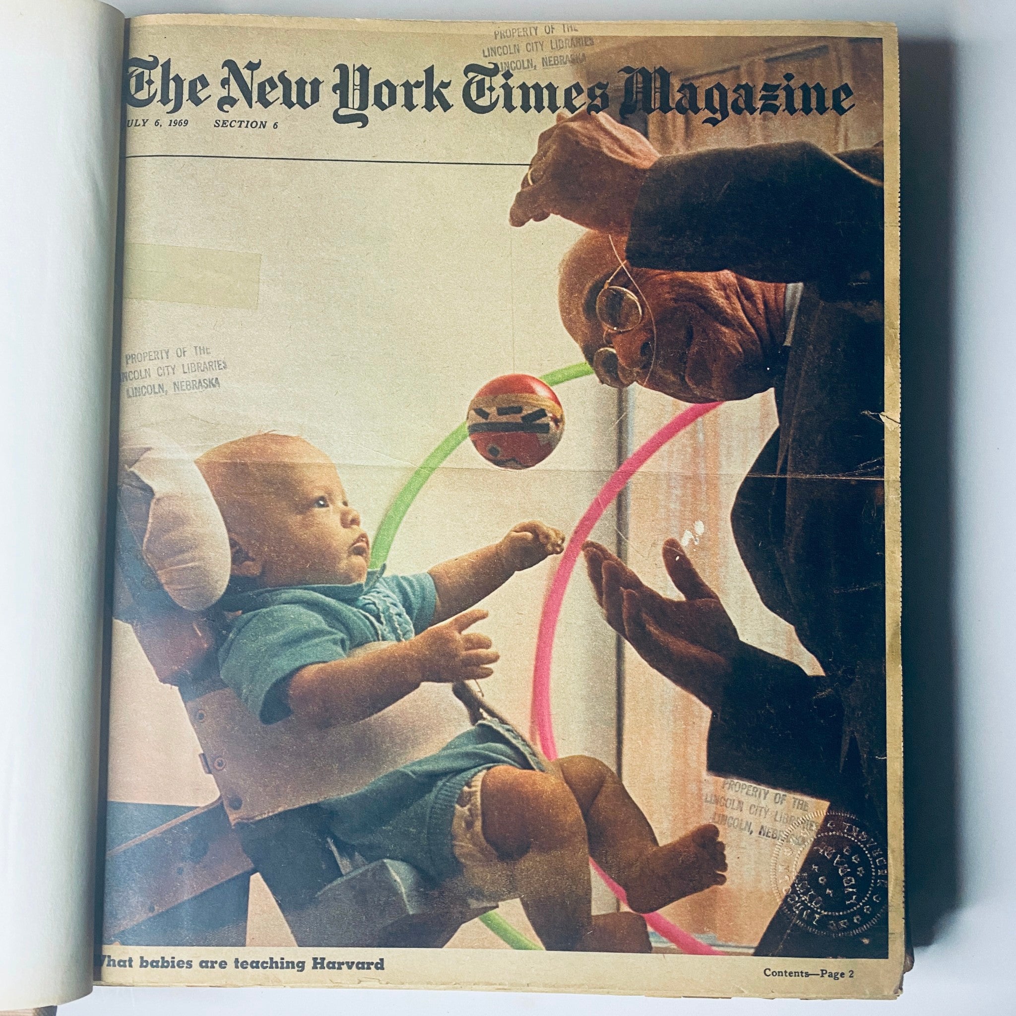 Cover of The New York Times Magazine from July 6, 1969, showcasing a baby playing with a colorful ball while a man interacts with him, highlighting cultural insights from the era.