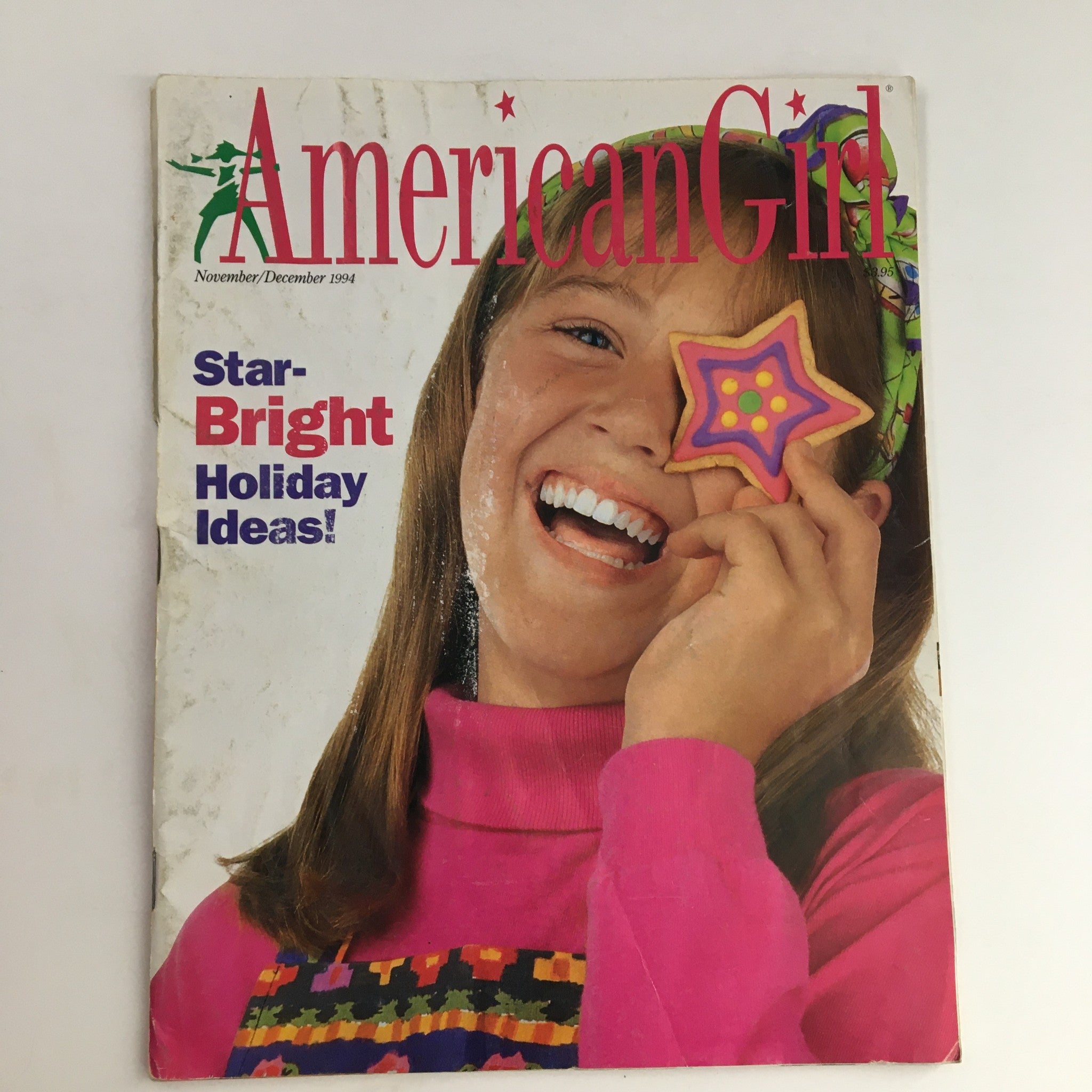Cover of American Girl Magazine November 1994 featuring the title 'Star-Bright Holiday Ideas!' with a smiling girl holding a decorated cookie, capturing the essence of creativity and nostalgia.