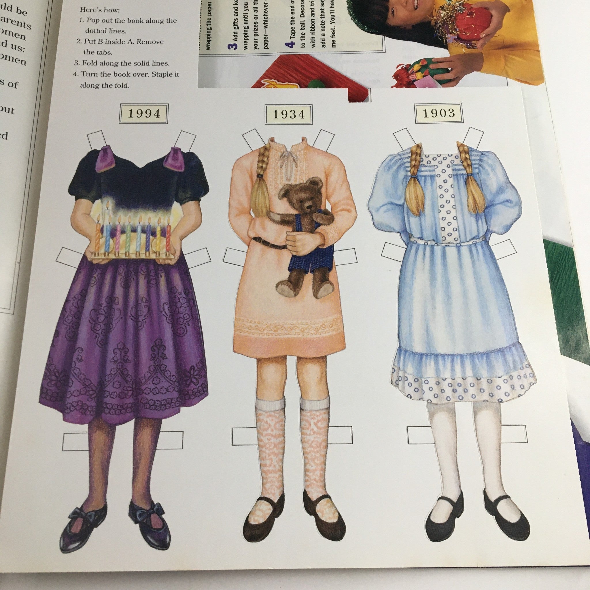 Paper doll outfits from American Girl Magazine November 1994, including clothing from 1994, 1934, and 1903, highlighting historical fashion for girl dolls.