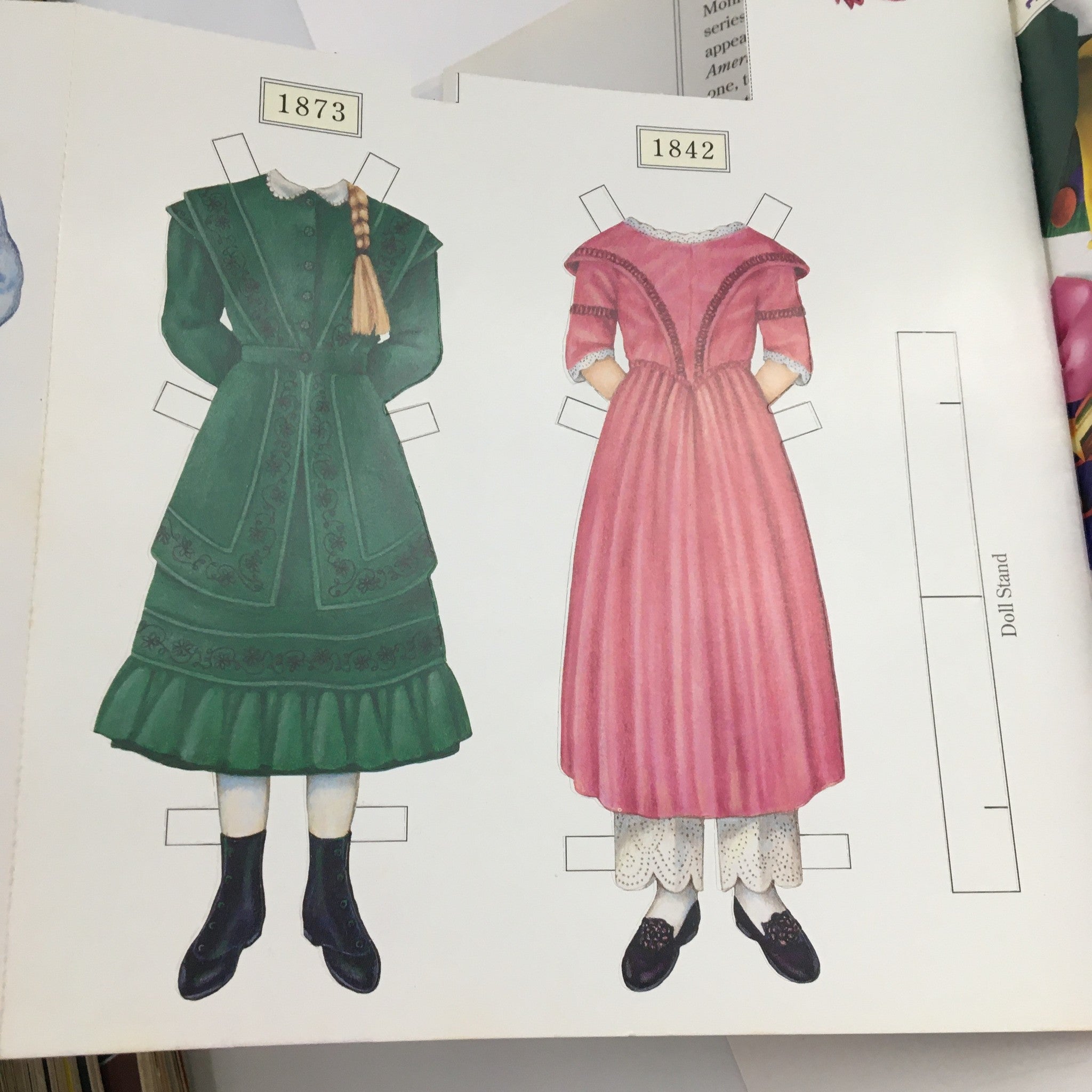 Illustration of historical outfits from American Girl Magazine November 1994, featuring clothing styles from 1873 and 1842 designed for paper dolls.