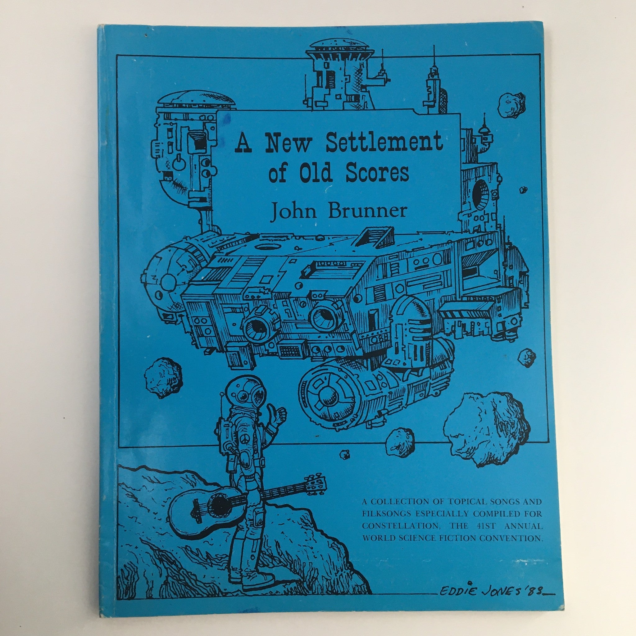 Cover of 1988 A New Settlement of Old Scores by John Brunner, featuring a blue background with an illustration of a spaceship and an astronaut holding a guitar, representing vintage science fiction and music.