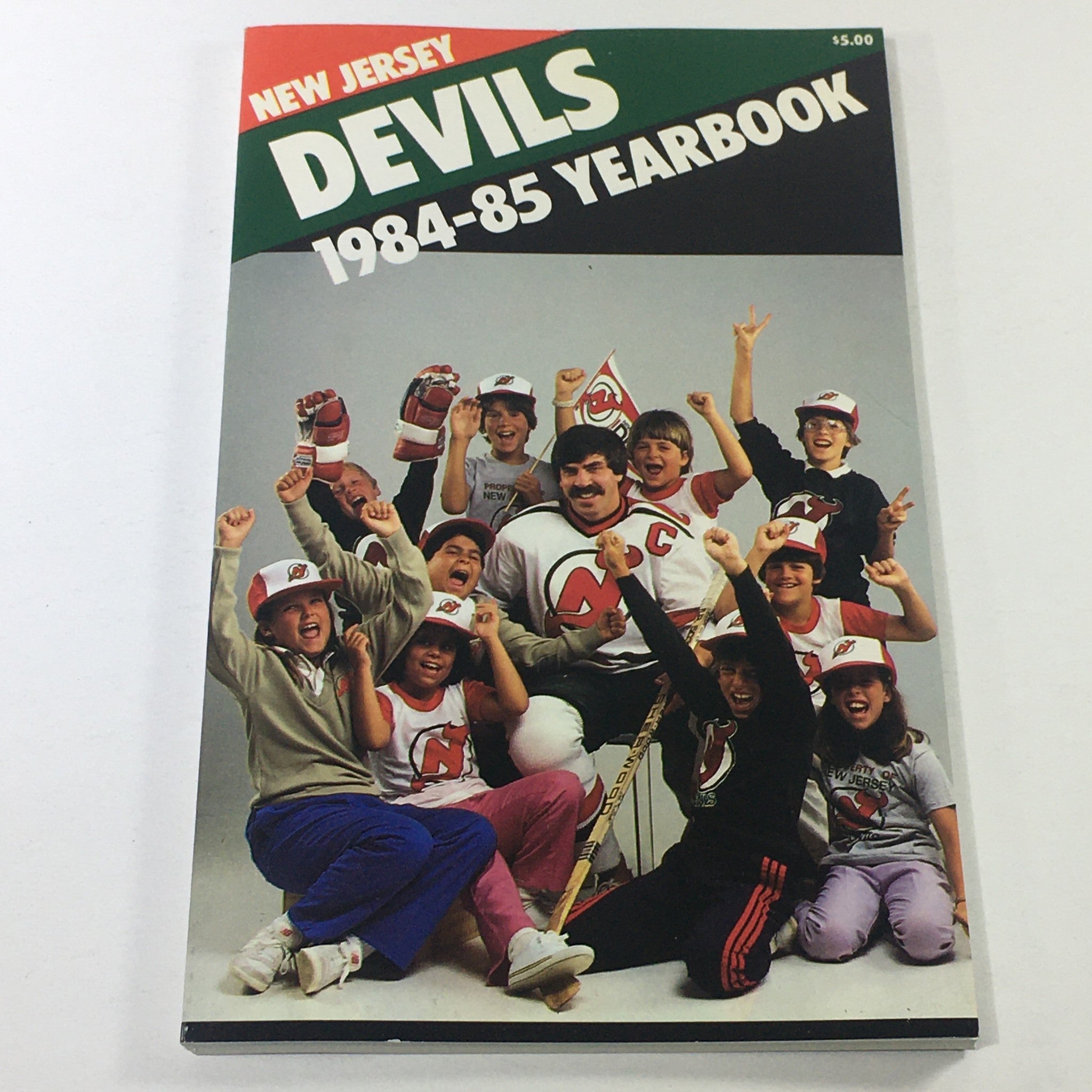 VTG NHL Official Yearbook 1984-1985 - New Jersey Devils team photo featuring fans and players celebrating.