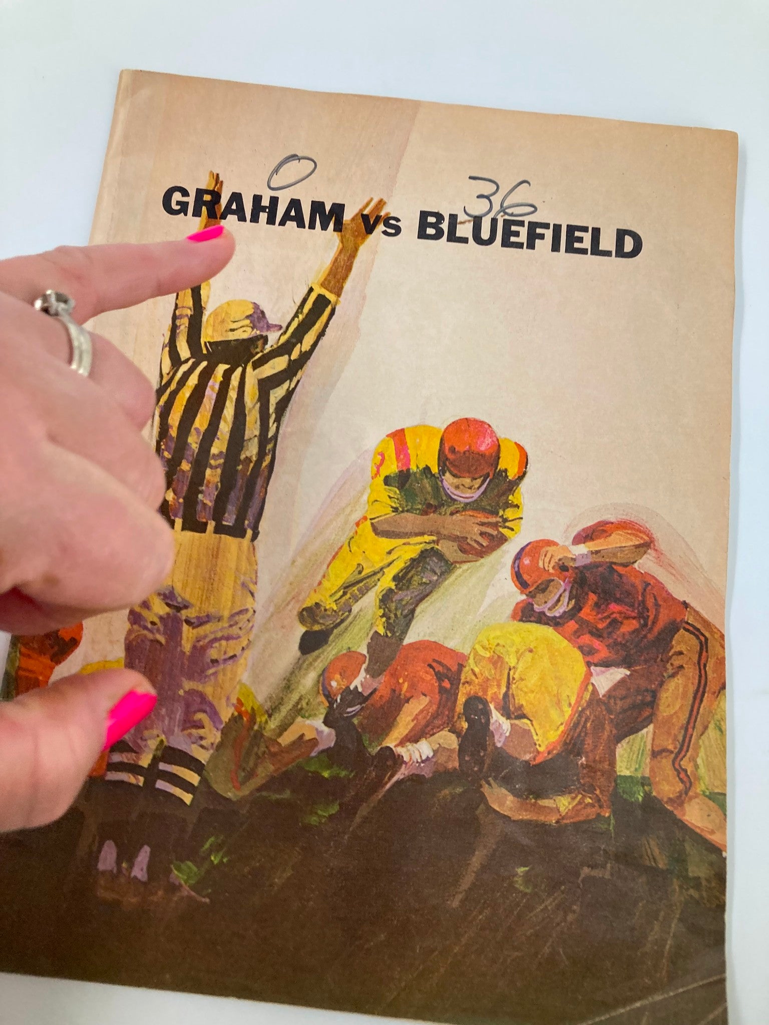 Close-up of the cover of the 1949 High School Football Graham G-Men vs Bluefield Beavers Official Program with a finger pointing at the score.