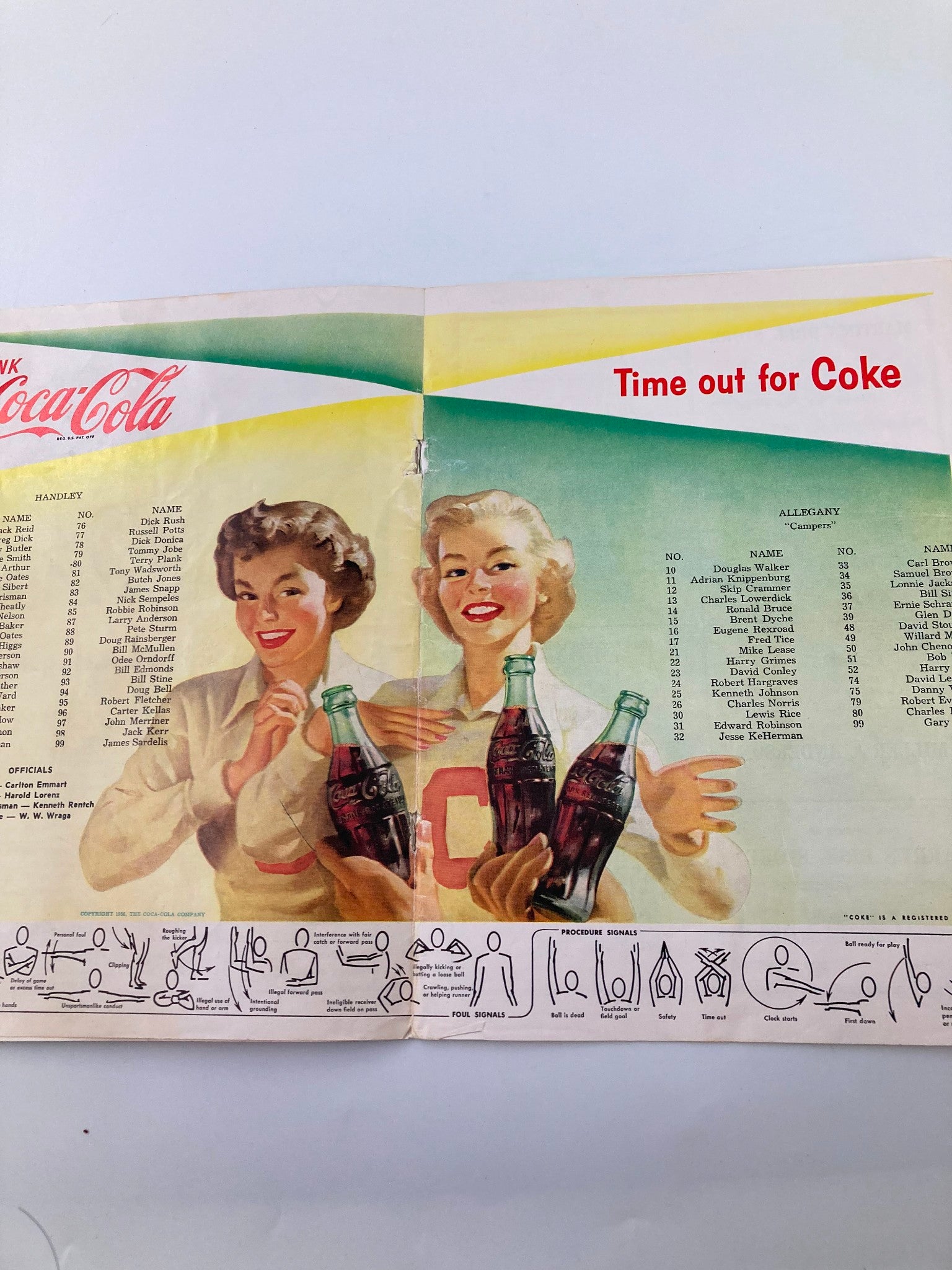 VTG September 22 1956 Football Handley vs Allegany Official Program showcasing two women promoting Coca-Cola while holding bottles. The program includes player rosters for Handley and Allegany High Schools.