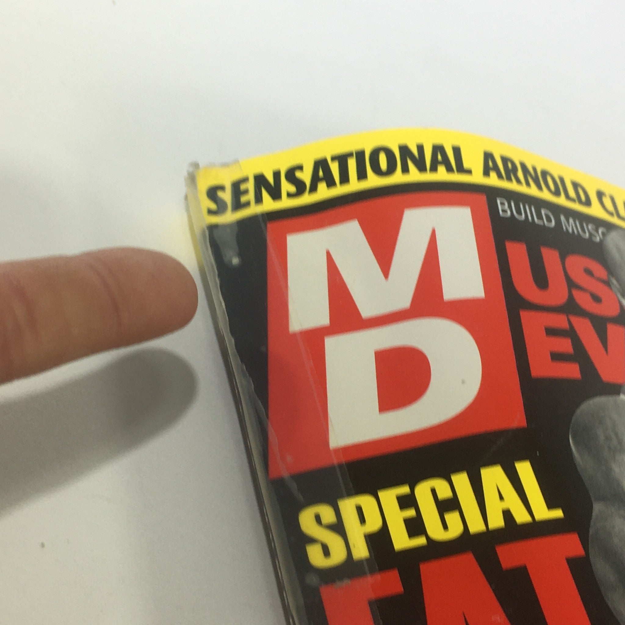 Close-up of the Muscular Development Magazine June 2005, pointing out the bold headline 'SENSATIONAL ARNOLD CLASSIC ISSUE', emphasizing its significance in bodybuilding history.