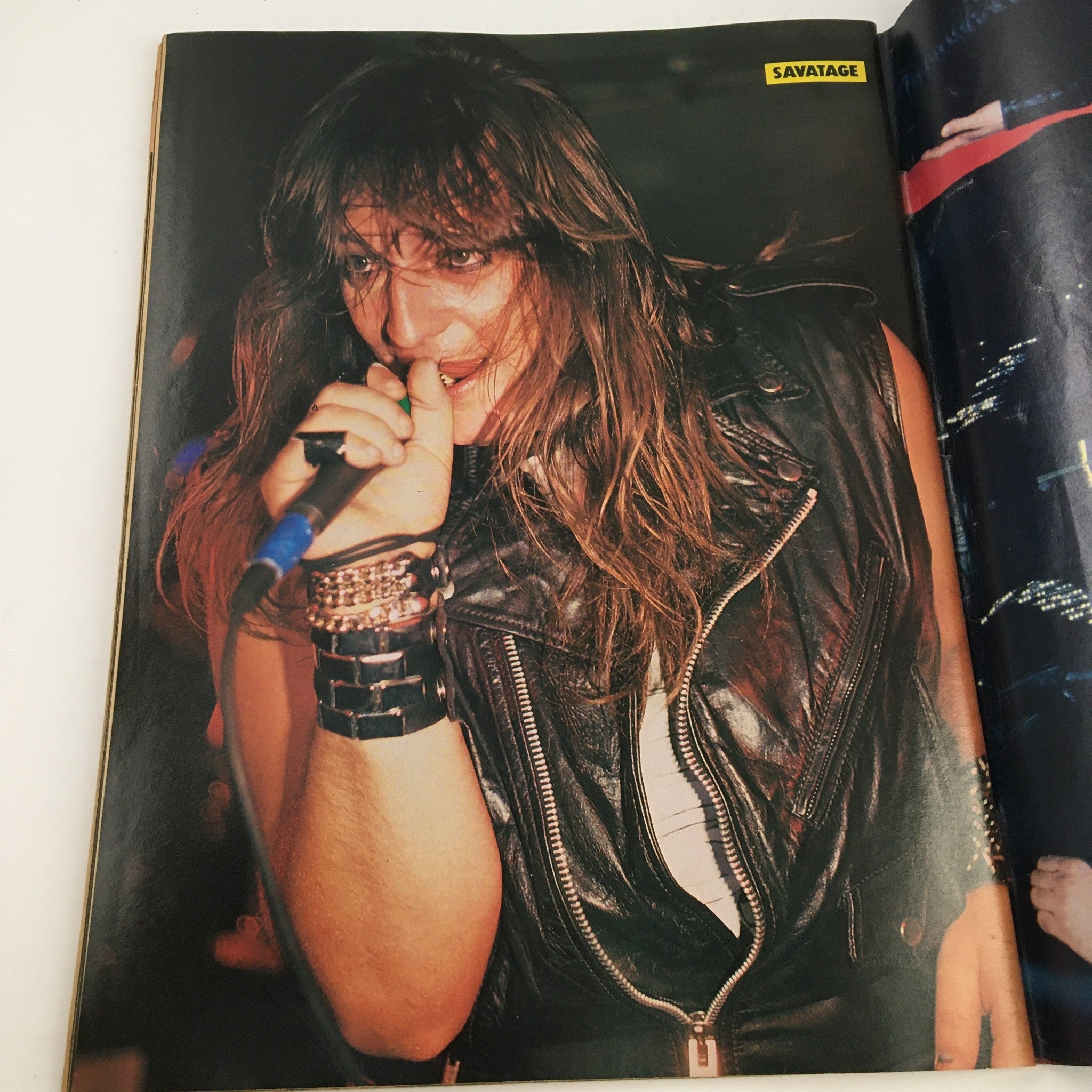 Rock Scene Metal Mania Magazine July 1986 featuring a live performance of a male vocalist with long hair in a leather vest, capturing the essence of 1980s metal music.