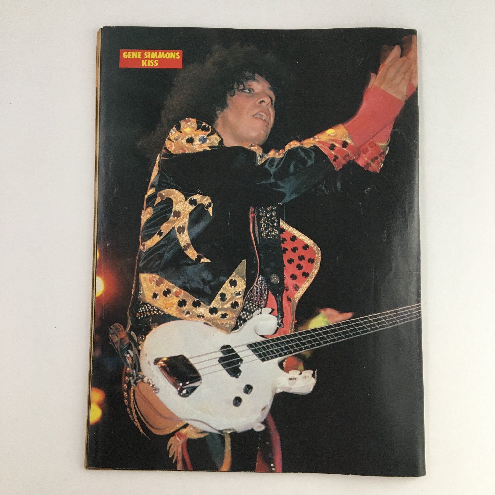 Rock Scene Metal Mania Magazine July 1986 showcasing Gene Simmons from KISS during a live performance, dressed in a flamboyant outfit, exemplifying the vibrant rock scene of the 1980s.