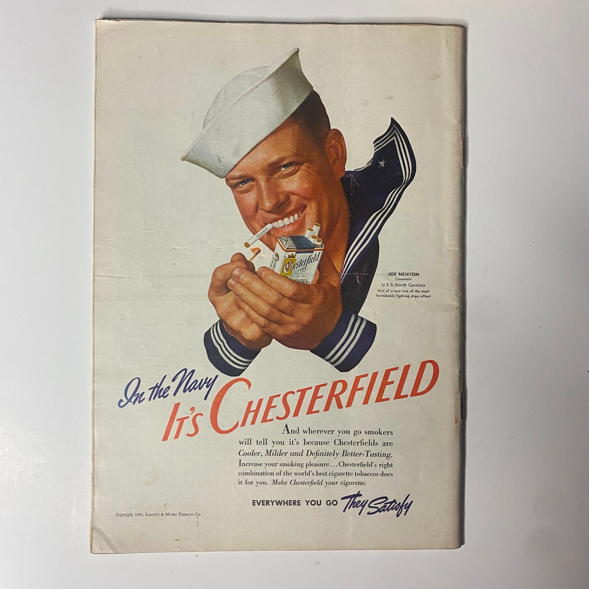 Vintage Chesterfield cigarette advertisement from 1941, featuring a smiling U.S. Navy sailor promoting Chesterfield cigarettes, emphasizing their cooler and milder taste.