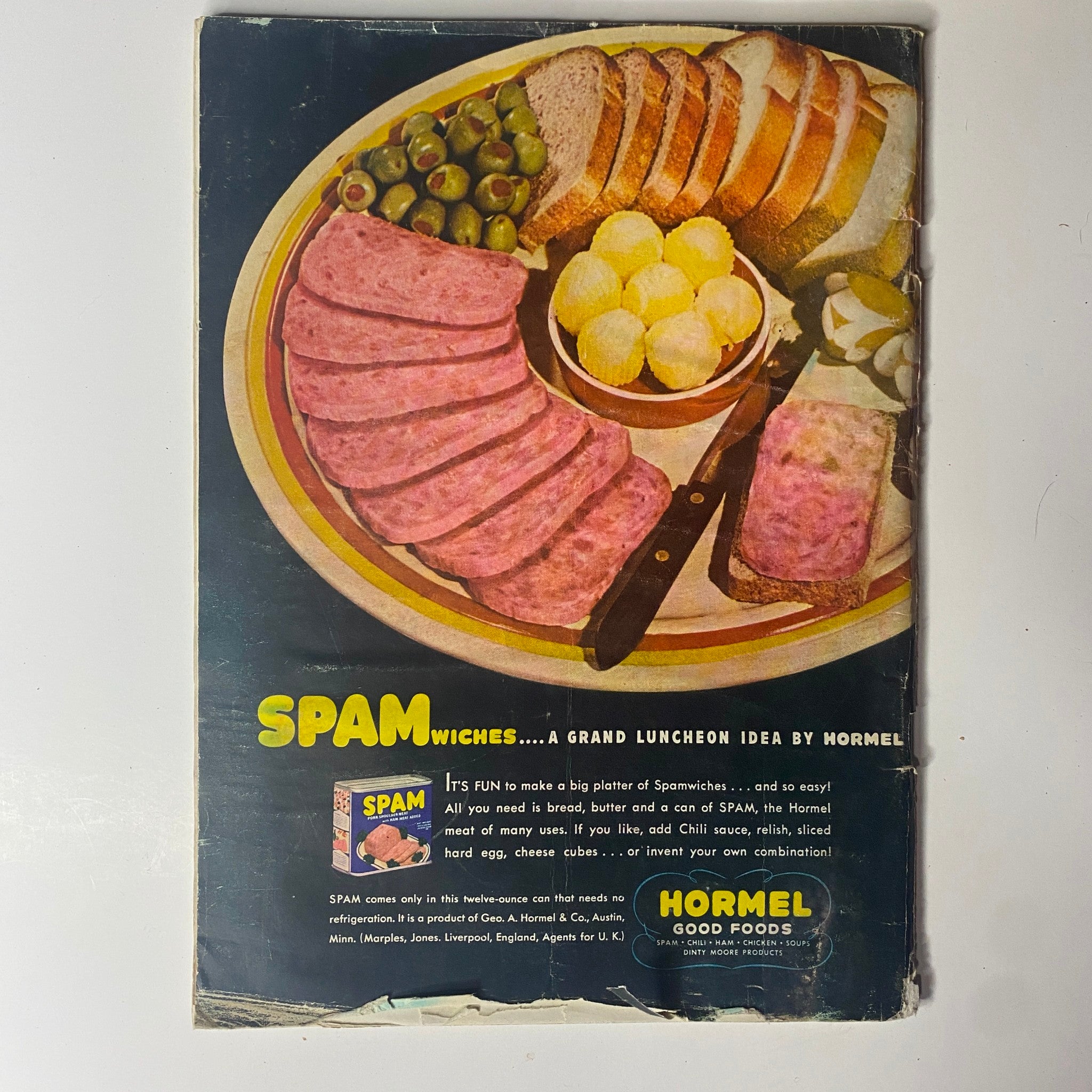 Vintage advertisement for Hormel's Spam, displaying a platter of Spam sandwiches alongside bread, olives, and butter balls, showcasing a 1940s luncheon idea.