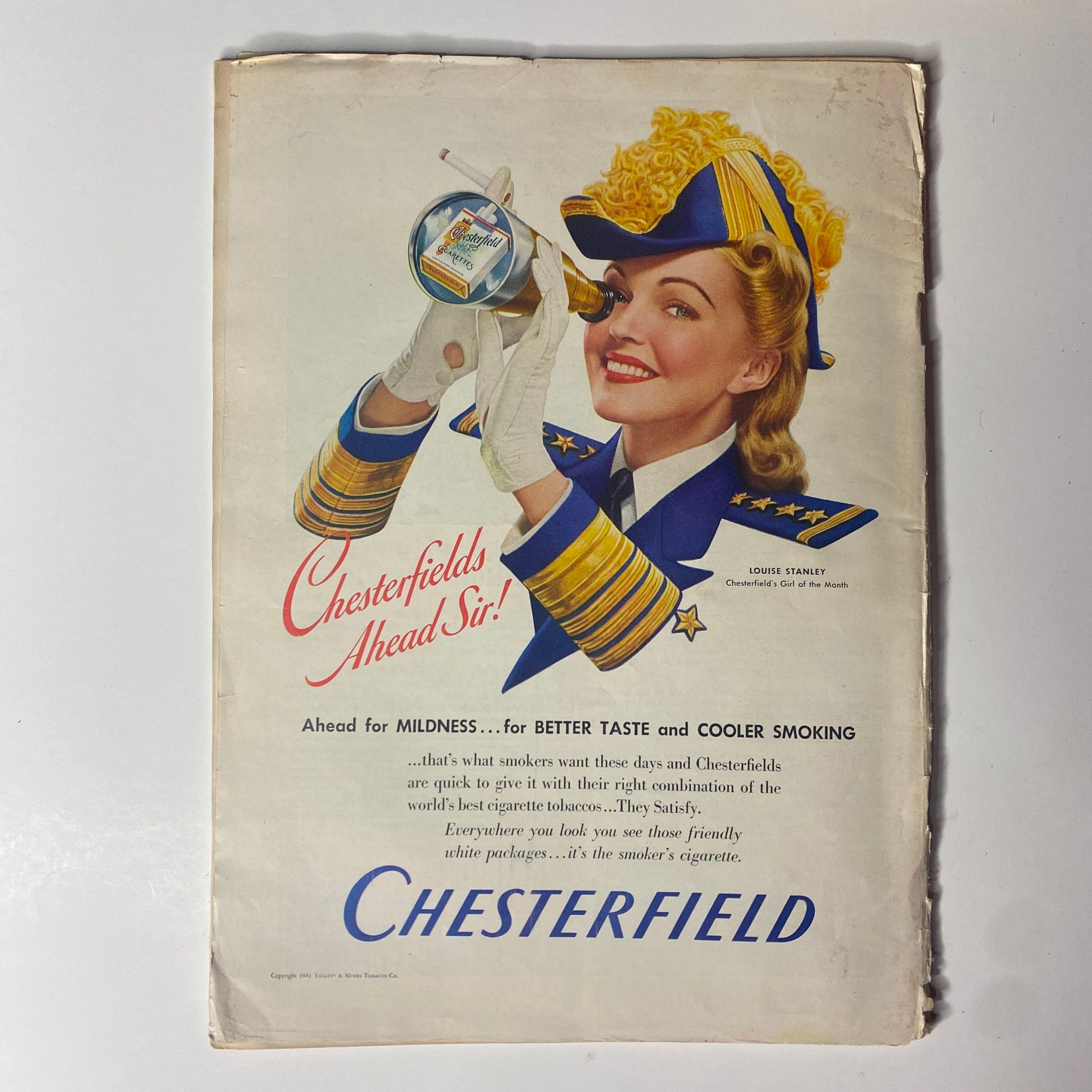 Advertisement in Time Magazine March 31, 1941 Vol 37 No. 13 for Chesterfield cigarettes, showcasing a smiling woman in a military-style uniform promoting the brand with a canister, emphasizing mildness and flavor.