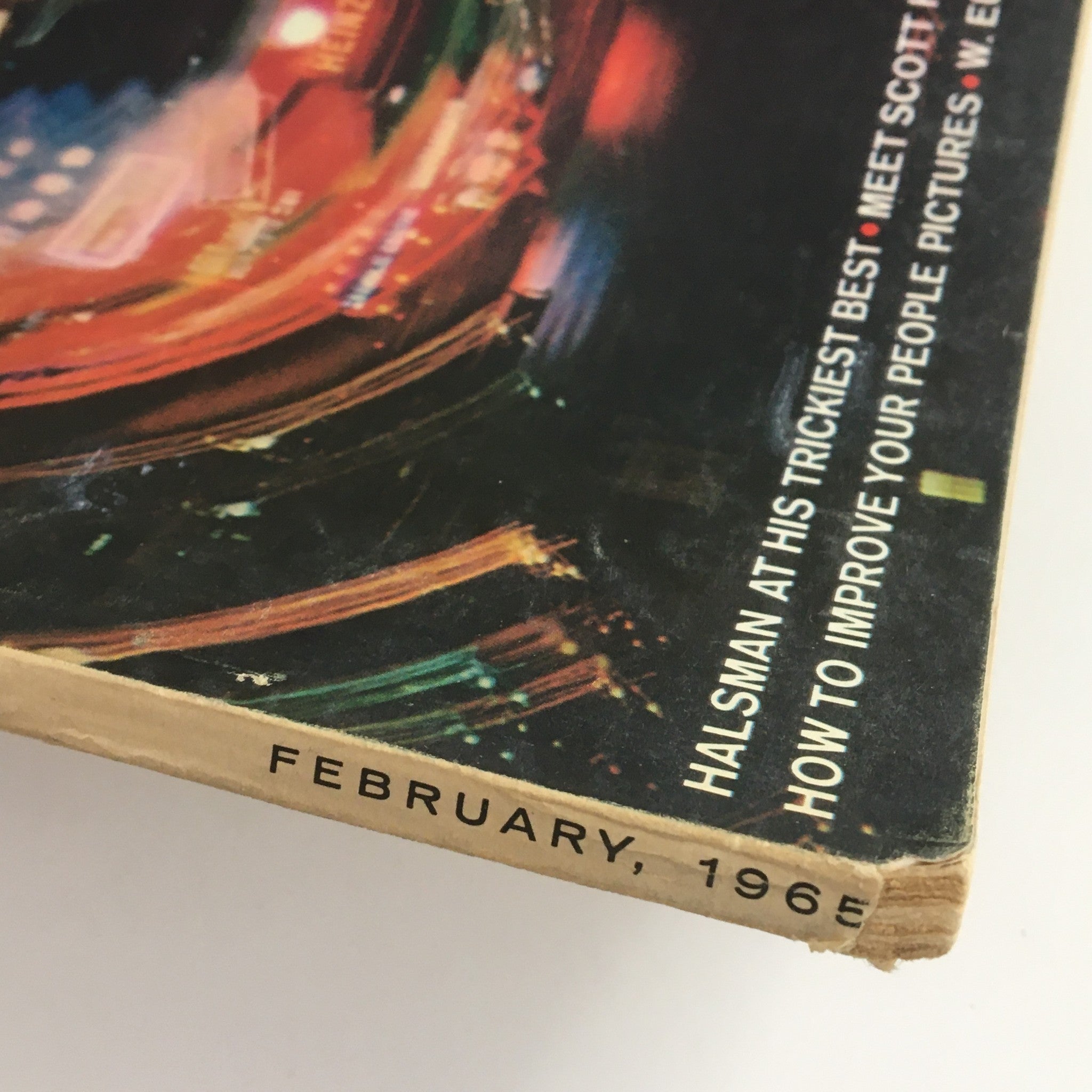 Close-up view of the February 1965 Popular Photography magazine featuring Scott Hyde, highlighting the date on the spine with colorful graphics that reflect the vibrant photography style of the era.