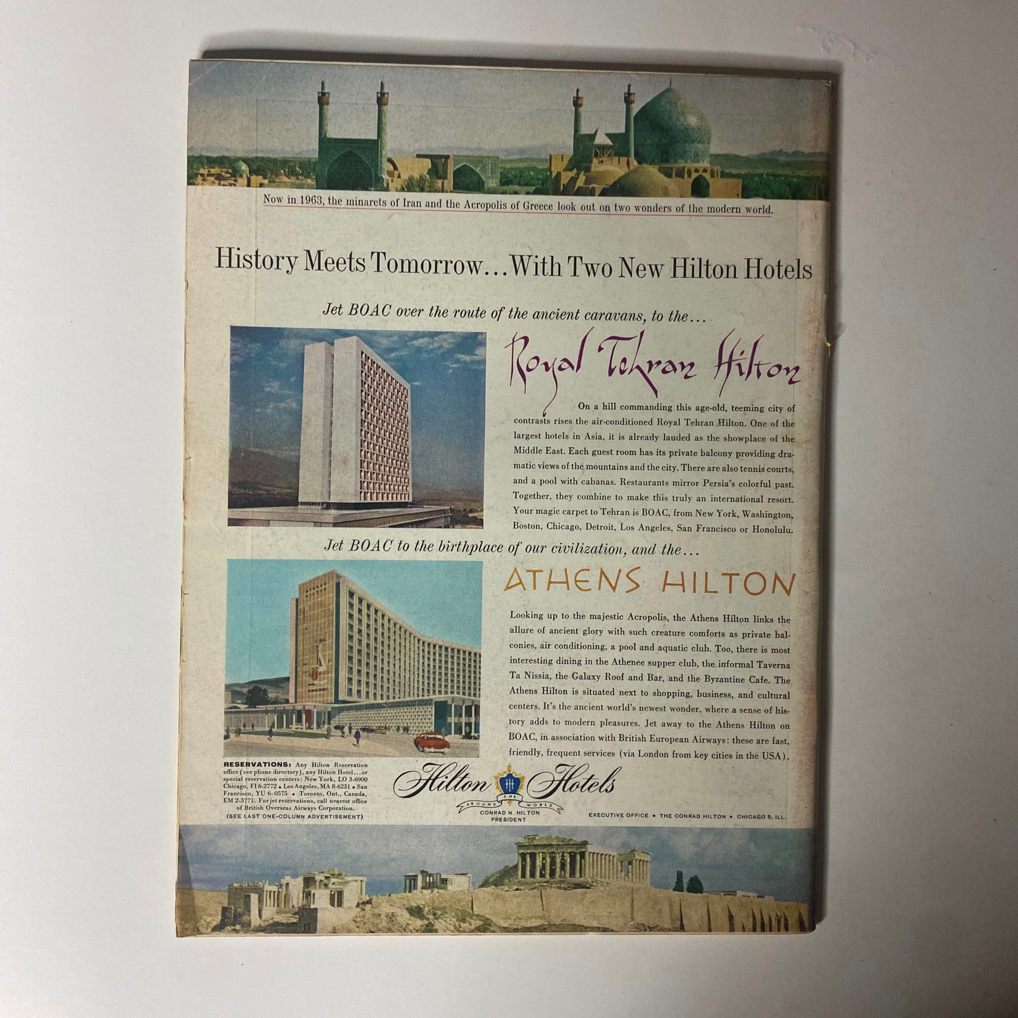 Historical advertisement featuring the Royal Tehran Hilton and Athens Hilton hotels. The image highlights the modern architecture of both hotels, along with a scenic view of the Acropolis in Greece, as seen in the vintage Time Magazine from February 22, 1963, Vol 81 No. 8 featuring conductor George Szell.