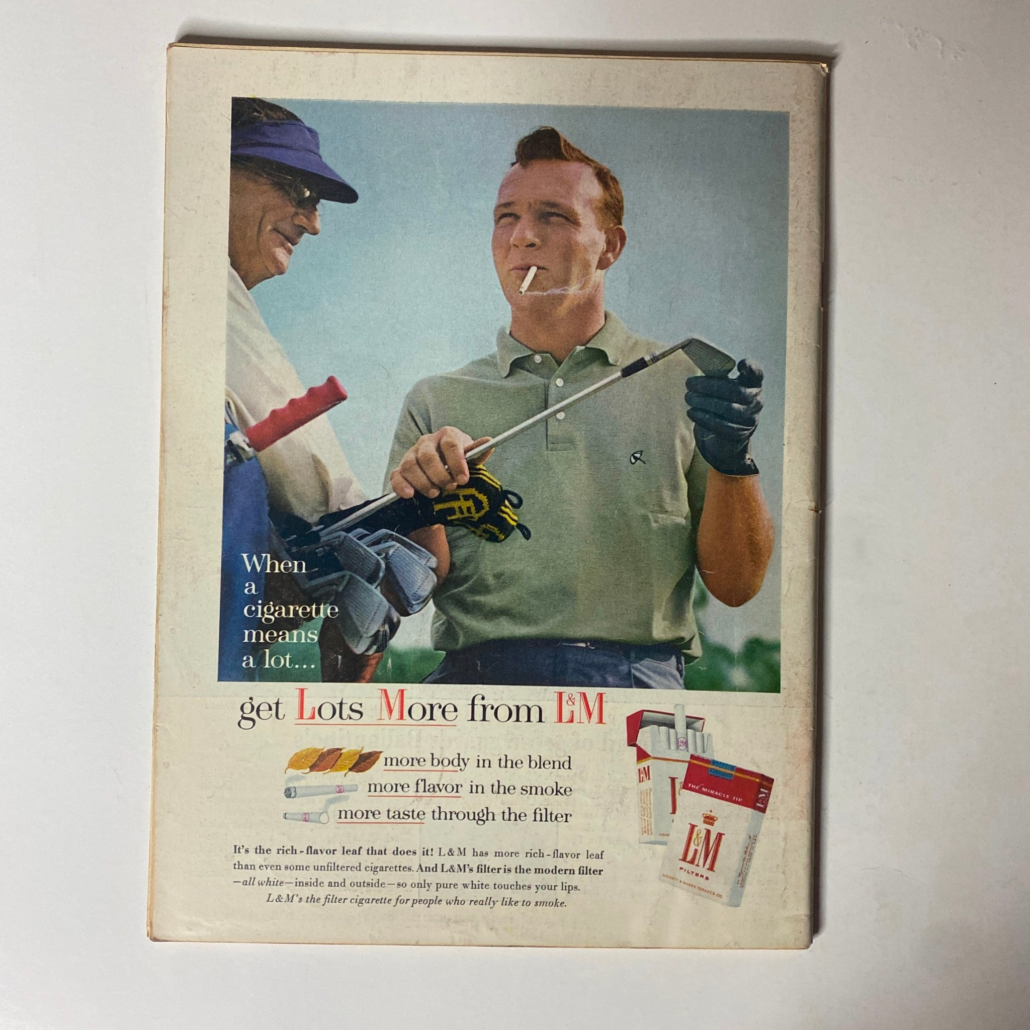 Vintage advertisement in Time Magazine featuring two men on a golf course, promoting L&M cigarettes, showcasing a blend of leisure and smoking culture in the 1960s.