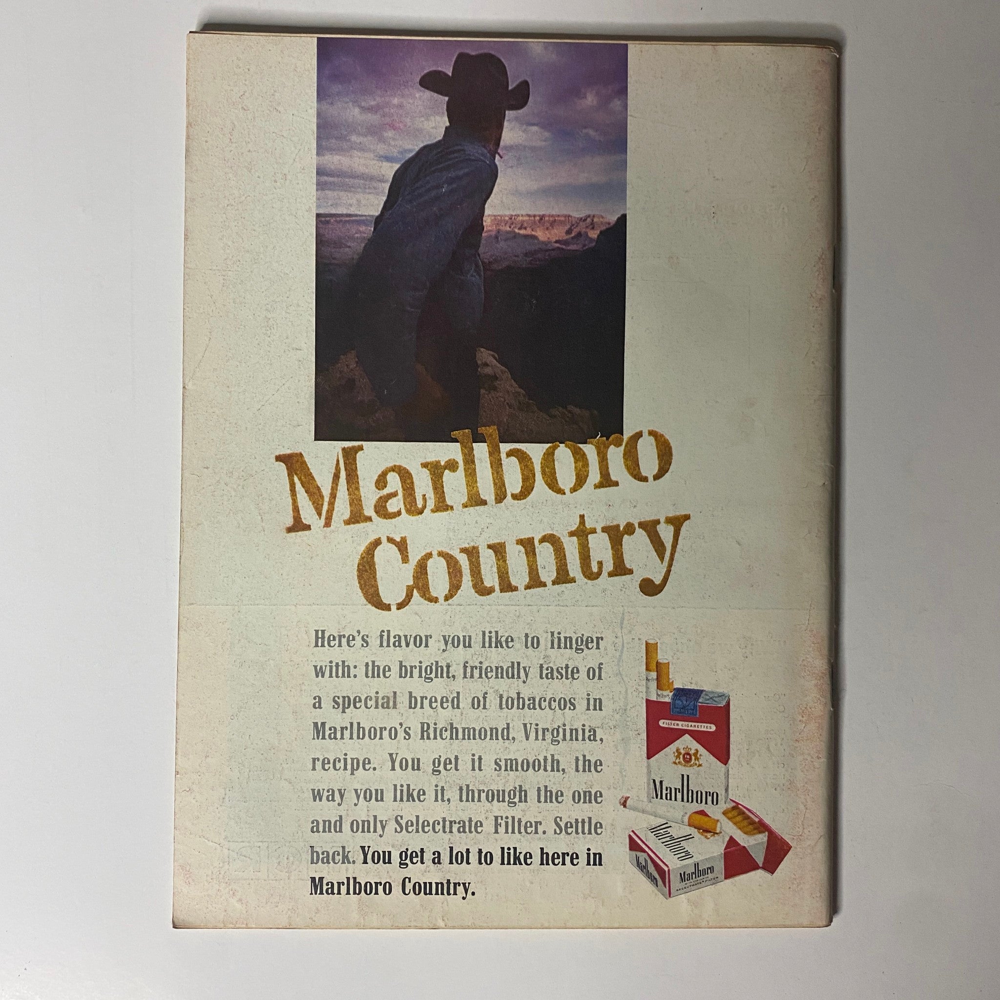 Vintage advertisement for Marlboro featuring a cowboy overlooking a landscape, emphasizing the slogan "Marlboro Country". This illustration complements the Time Magazine from April 12, 1963, Vol 81 No. 15, showcasing Tunku Abdul Rahman on the cover.
