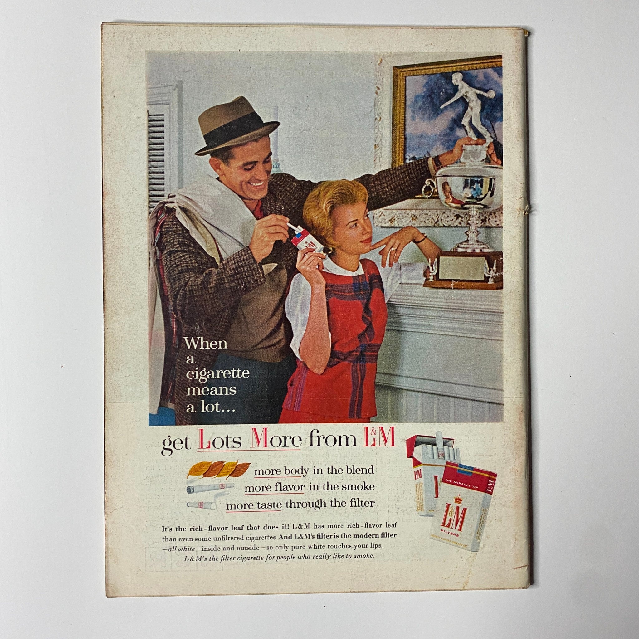 Vintage L&M cigarette advertisement featuring a man and woman promoting the brand, with the text discussing the quality of the cigarettes.