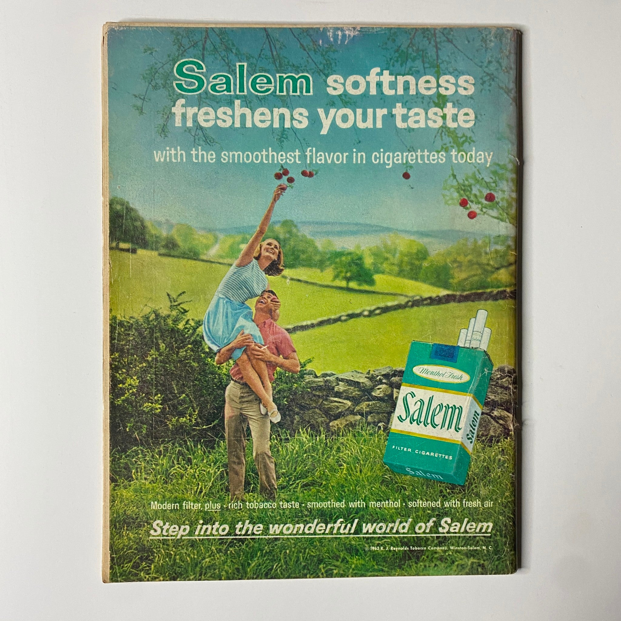 Vintage advertisement for Salem cigarettes featuring a couple in a scenic outdoor setting with the tagline 'Salem softness freshens your taste'. The ad highlights the smooth flavor of cigarettes and invites viewers to step into the wonderful world of Salem. Part of the Time Magazine issue from October 18, 1963, Vol. 82 No. 16 featuring Roger Staubach.