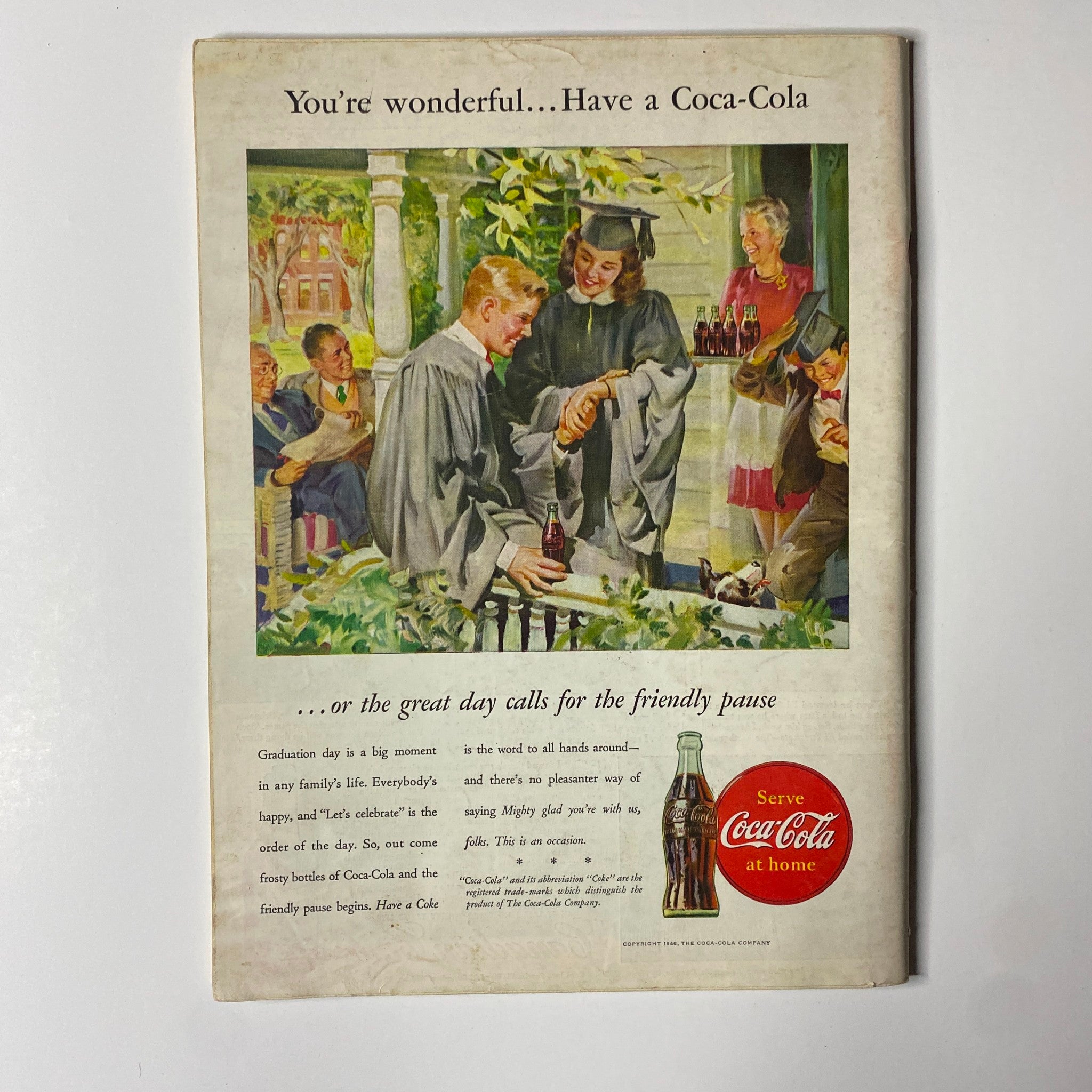 Vintage Coca-Cola advertisement featuring a graduation celebration scene. The image showcases graduates in caps and gowns enjoying Coca-Cola drinks with family and friends, highlighting a sense of joy and togetherness. This image relates to the Time Magazine May 6, 1946 Vol 47 No. 18 Elizabeth Arden issue.
