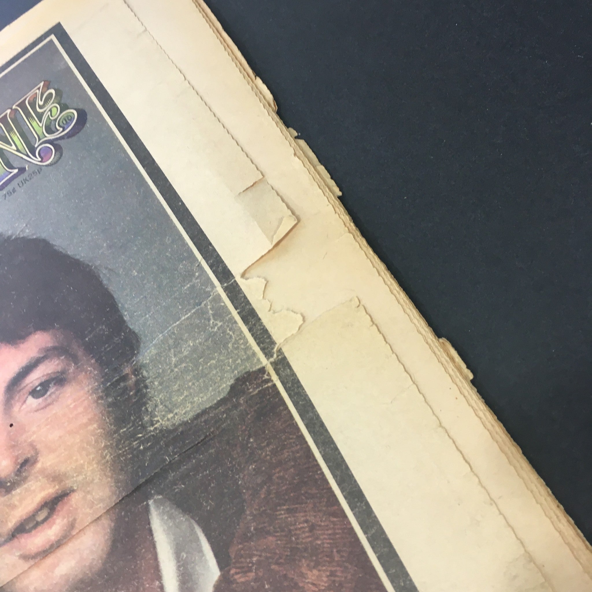 Image showing the top edge of the vintage Rolling Stone magazine from January 31, 1974, with noticeable wear and tear, including torn paper. The magazine title, alongside details of Paul McCartney and Dylan's tour, is partially visible.