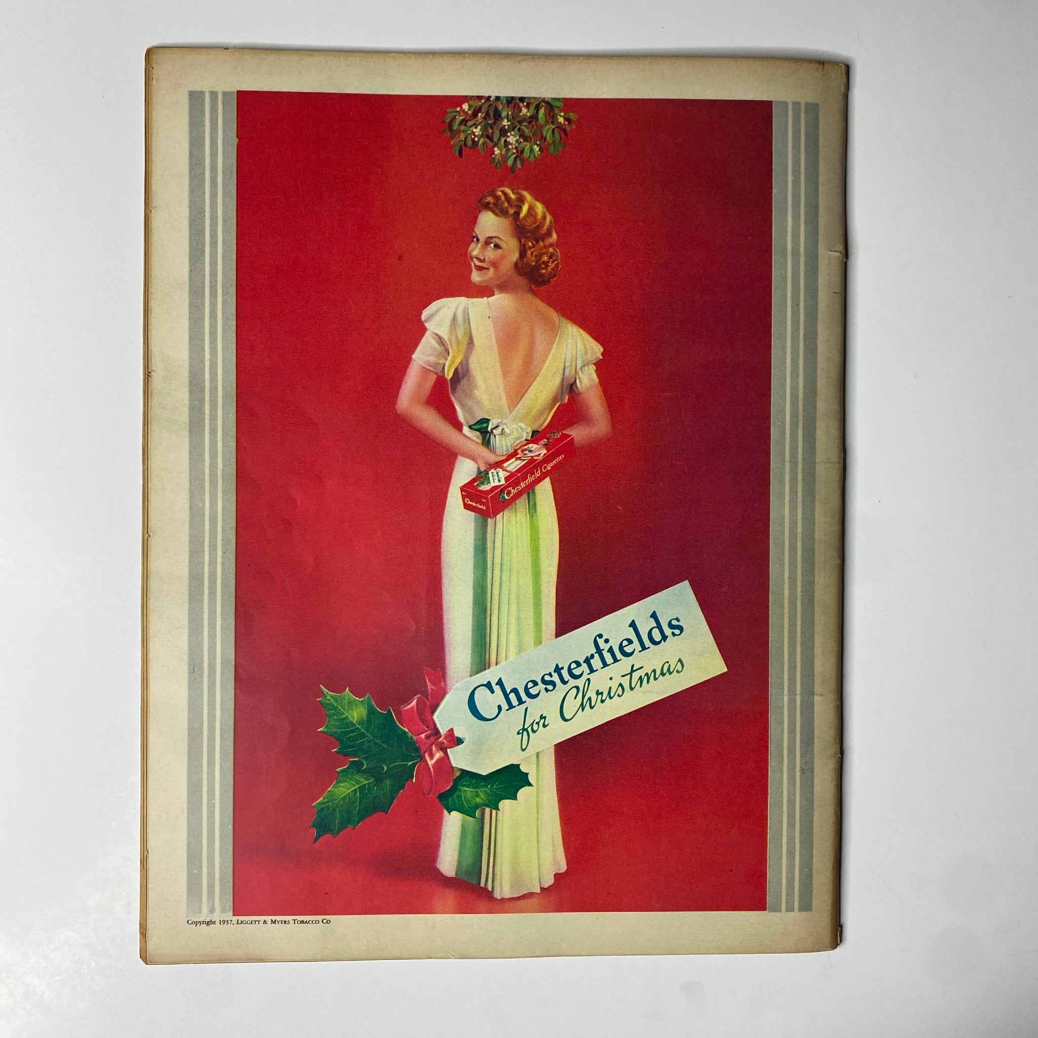 Cover page of Look Magazine December 21, 1937 with a festive illustration featuring a woman in a vintage dress holding a box, adorned with Christmas decorations and the caption 'Chesterfields for Christmas'. This collectible issue celebrates the holiday spirit.
