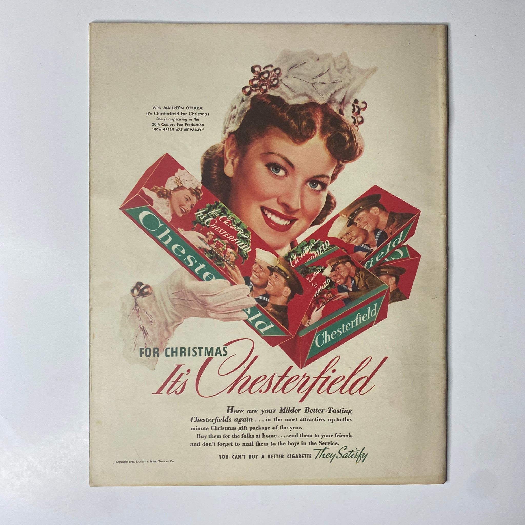 Look Magazine December 2, 1941 Christmas advertisement for Chesterfield cigarettes, featuring a smiling woman promoting festive packaging. This vintage illustration captures the marketing style of early 1940s America.