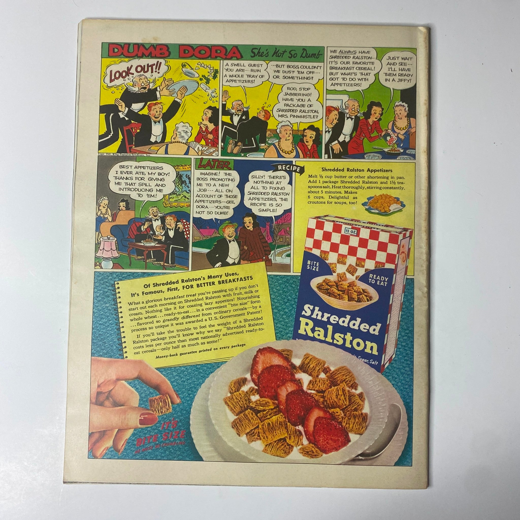 Vintage comic strip image titled 'Dumb Dora - She's Not So Dumb' featuring humorous panels with an illustration of characters in various comedic situations and a food advertisement for Shredded Ralston breakfast cereal, enhancing the nostalgic appeal related to the Look Magazine May 20, 1941 issue.