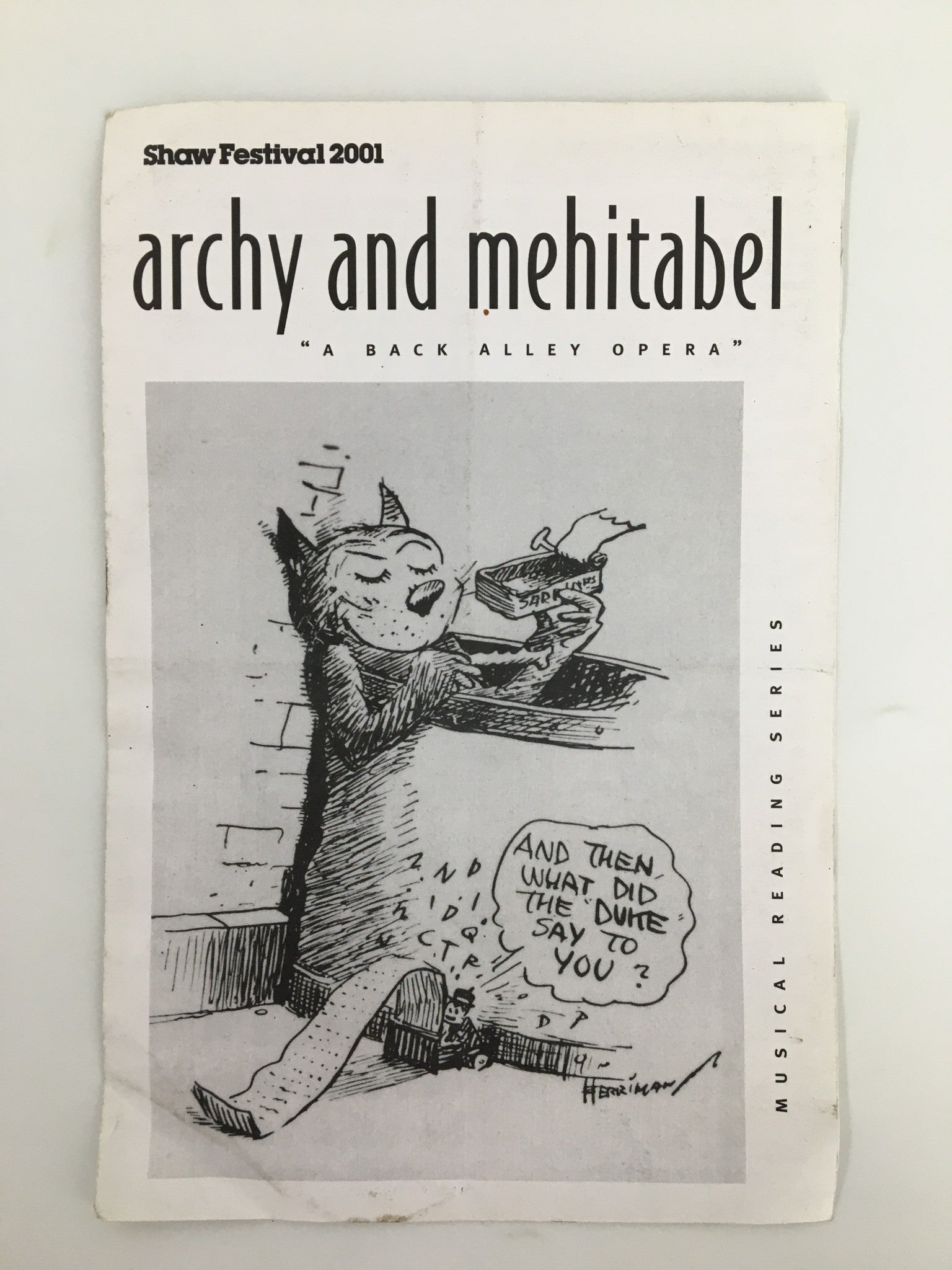 2001 Shaw Festival program for Archy and Mehitabel, featuring an illustration of a cat holding a book with a whimsical expression, highlighting its theatrical themes.