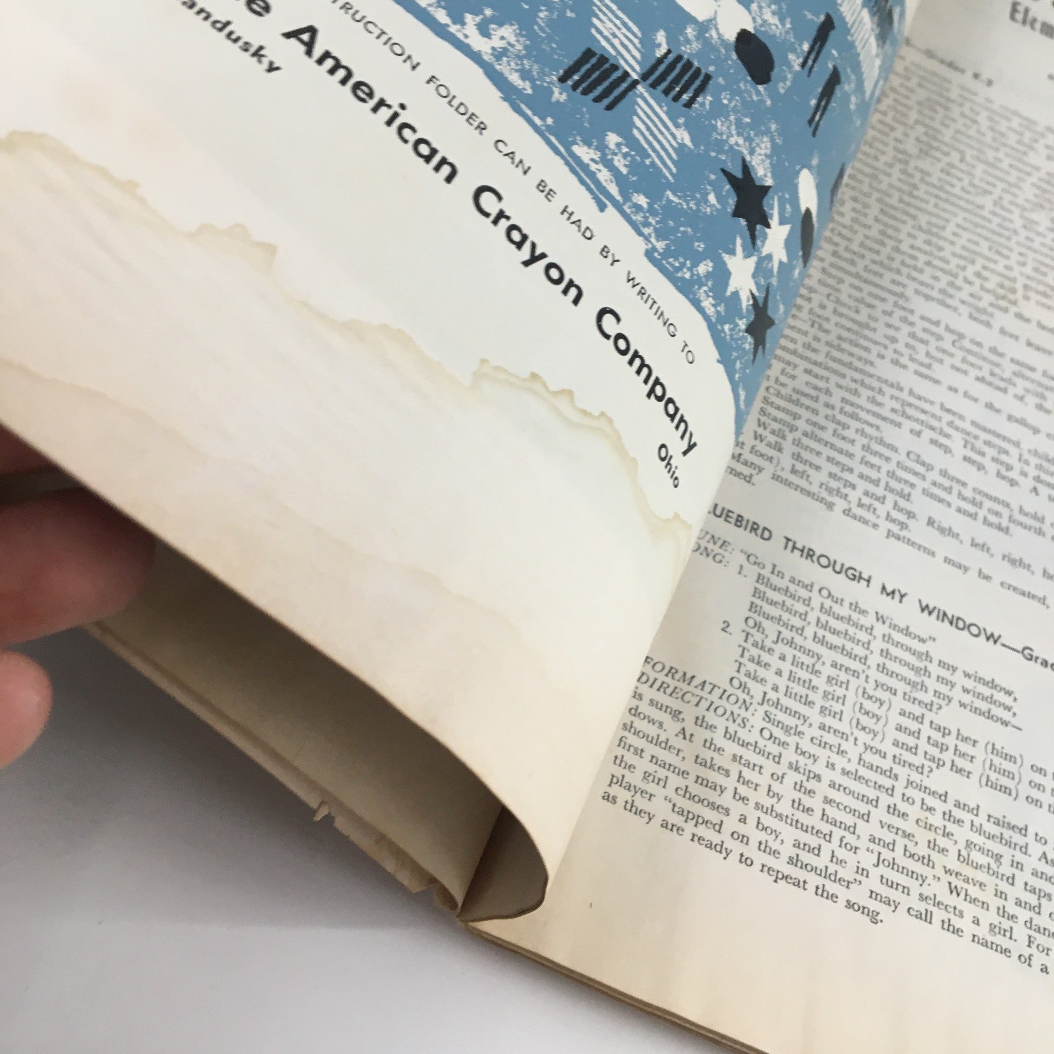 Close-up of the bottom edge of an interior page from The Instructor Magazine January 1959, showing water damage and aging effects, illustrating the magazine's vintage condition.