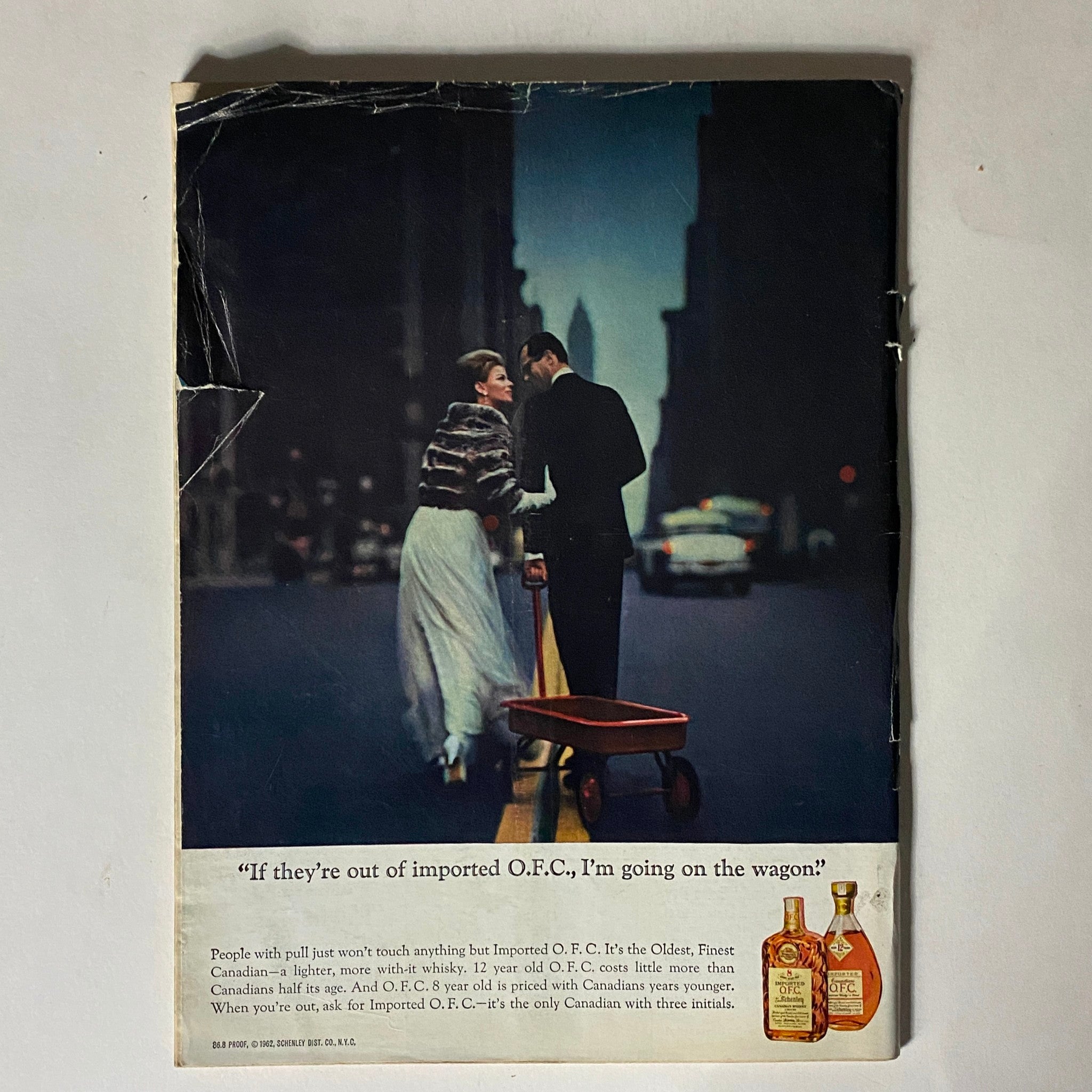 Back cover of The New Yorker magazine January 19, 1963, featuring an advertisement for imported O.F.C. whisky, depicting a couple in formal attire on a city street.