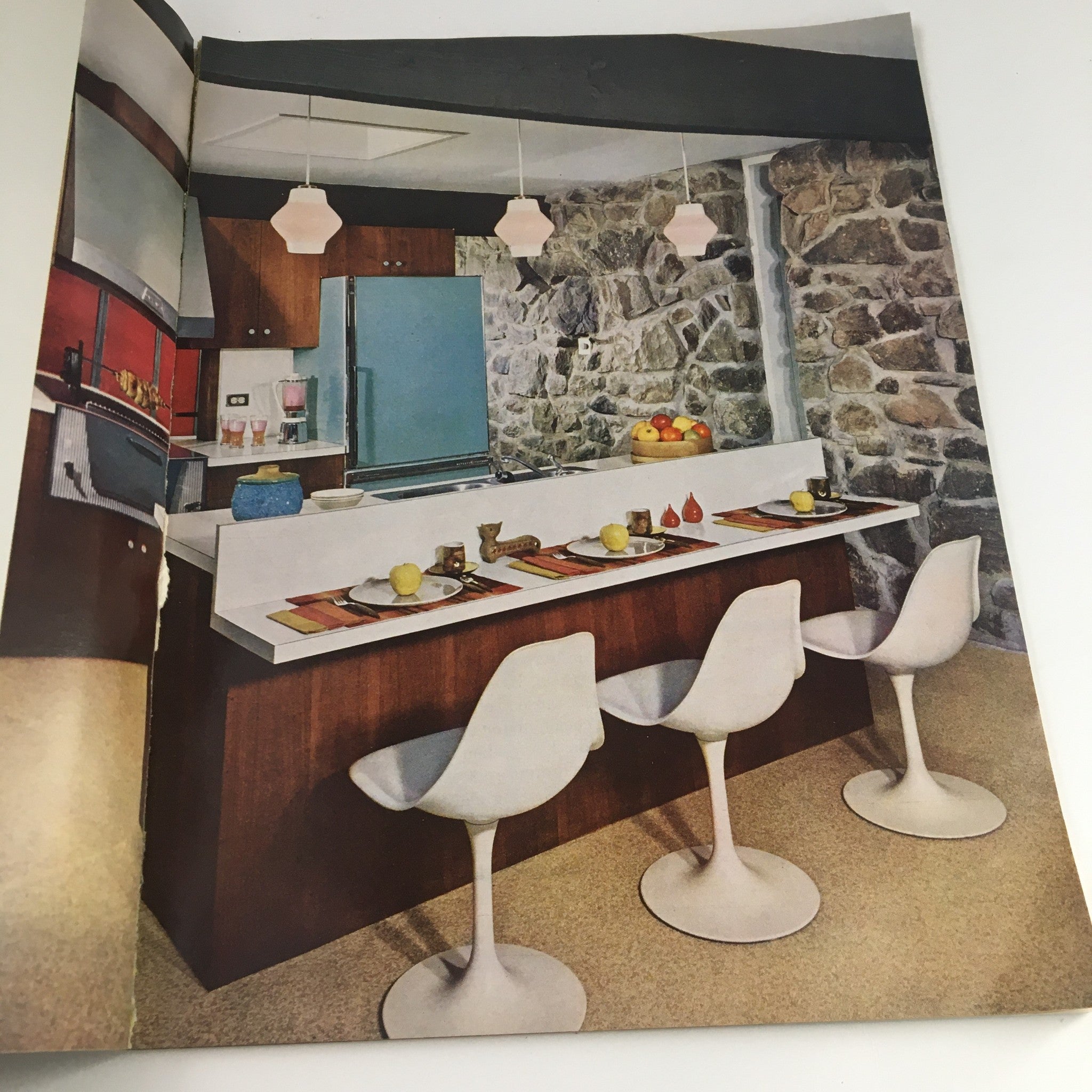 Better Homes & Gardens Magazine Kitchen Ideas 1963 - A contemporary kitchen design featuring a stone wall and sleek furniture, embodying the innovative style of the 1960s.