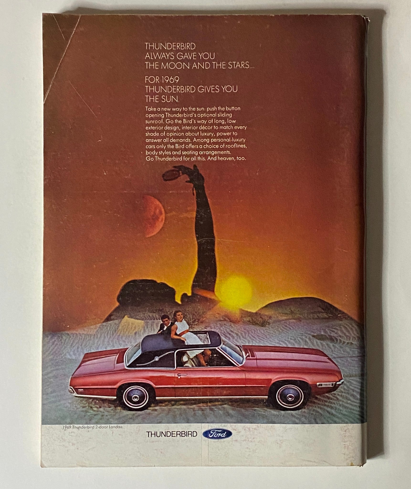 Vintage advertisement for the 1969 Thunderbird, featured in The New Yorker Complete Magazine November 23, 1968, showcasing a stylish car under a sunset with a couple, highlighting the luxury and design of the era.