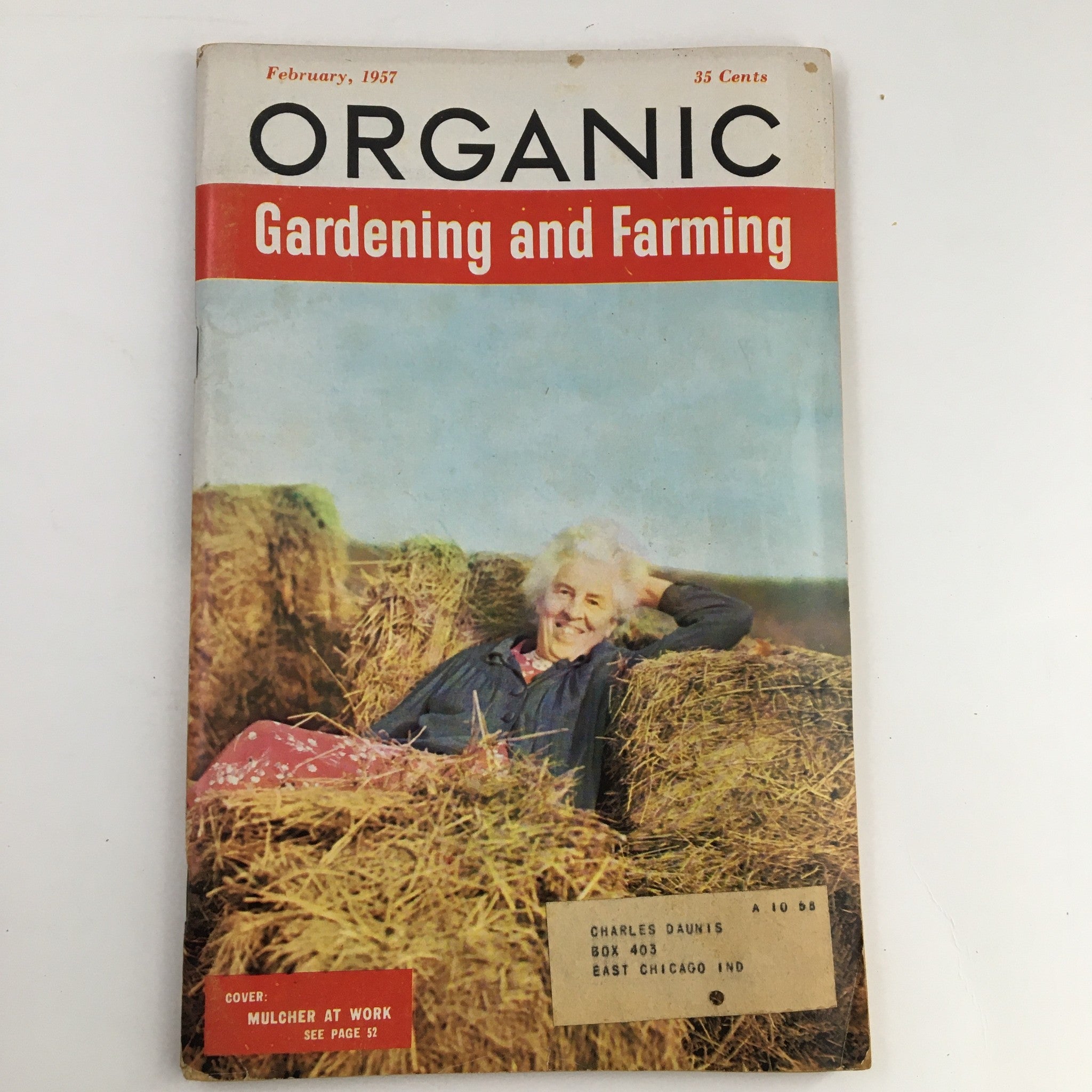 Organic Gardening and Farming February 1957 magazine cover featuring a smiling woman surrounded by hay, highlighting the theme 'The Hedge That Grows Vitamins'.