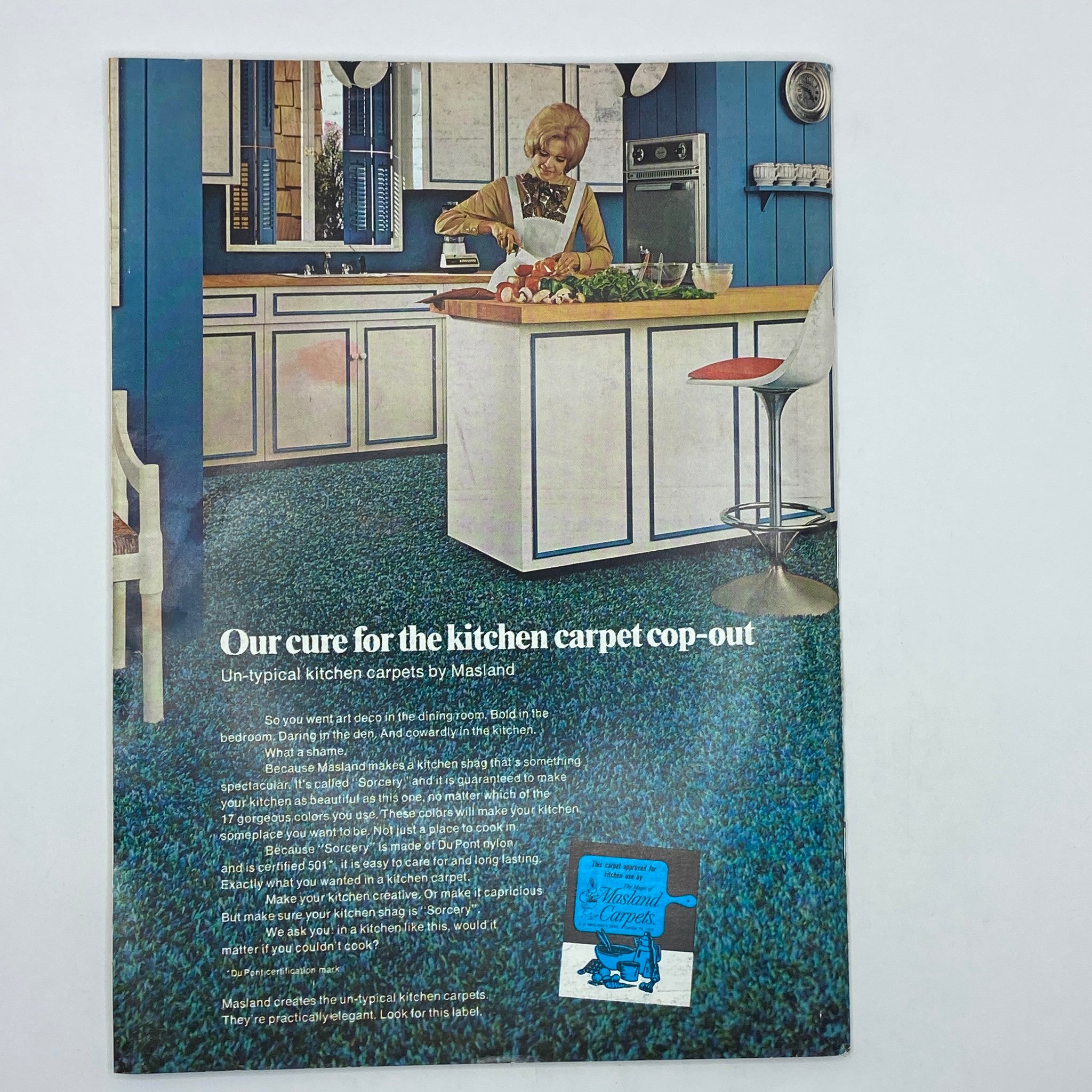 A vintage advertisement titled 'Our cure for the kitchen carpet cop-out' featuring a woman cooking in a stylish kitchen with blue walls and a Masland carpet, from The New Yorker Complete Magazine June 5, 1971.