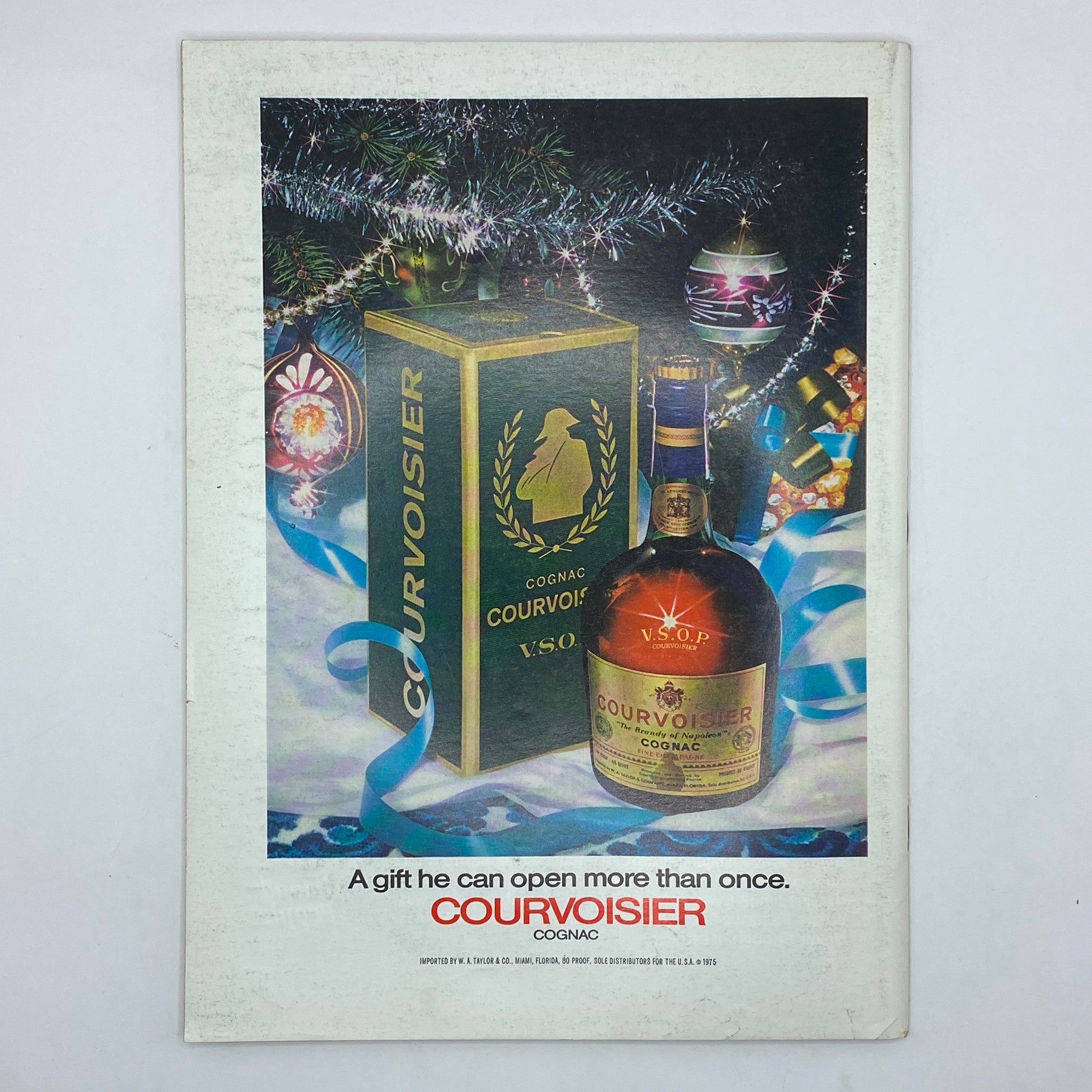 Advertisement for Courvoisier Cognac featured in The New Yorker Complete Magazine December 20, 1976, showcasing a festive holiday gift setting.