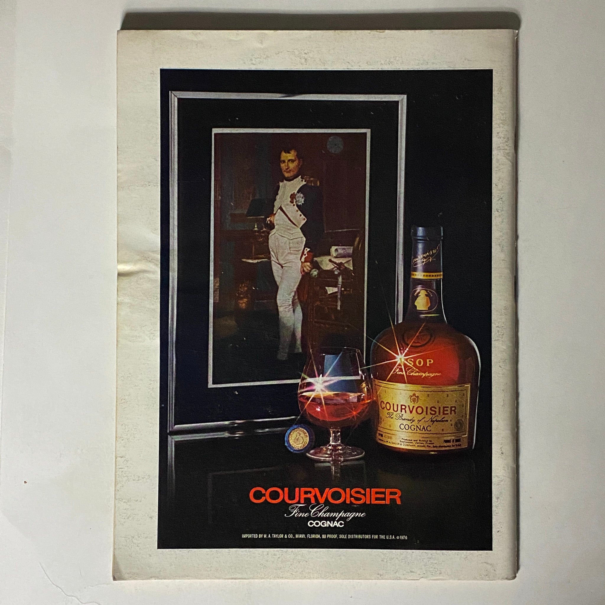 Vintage advertisement for Courvoisier Cognac in The New Yorker Complete Magazine March 14, 1977, showcasing a bottle and glass alongside a portrait of Napoleon.