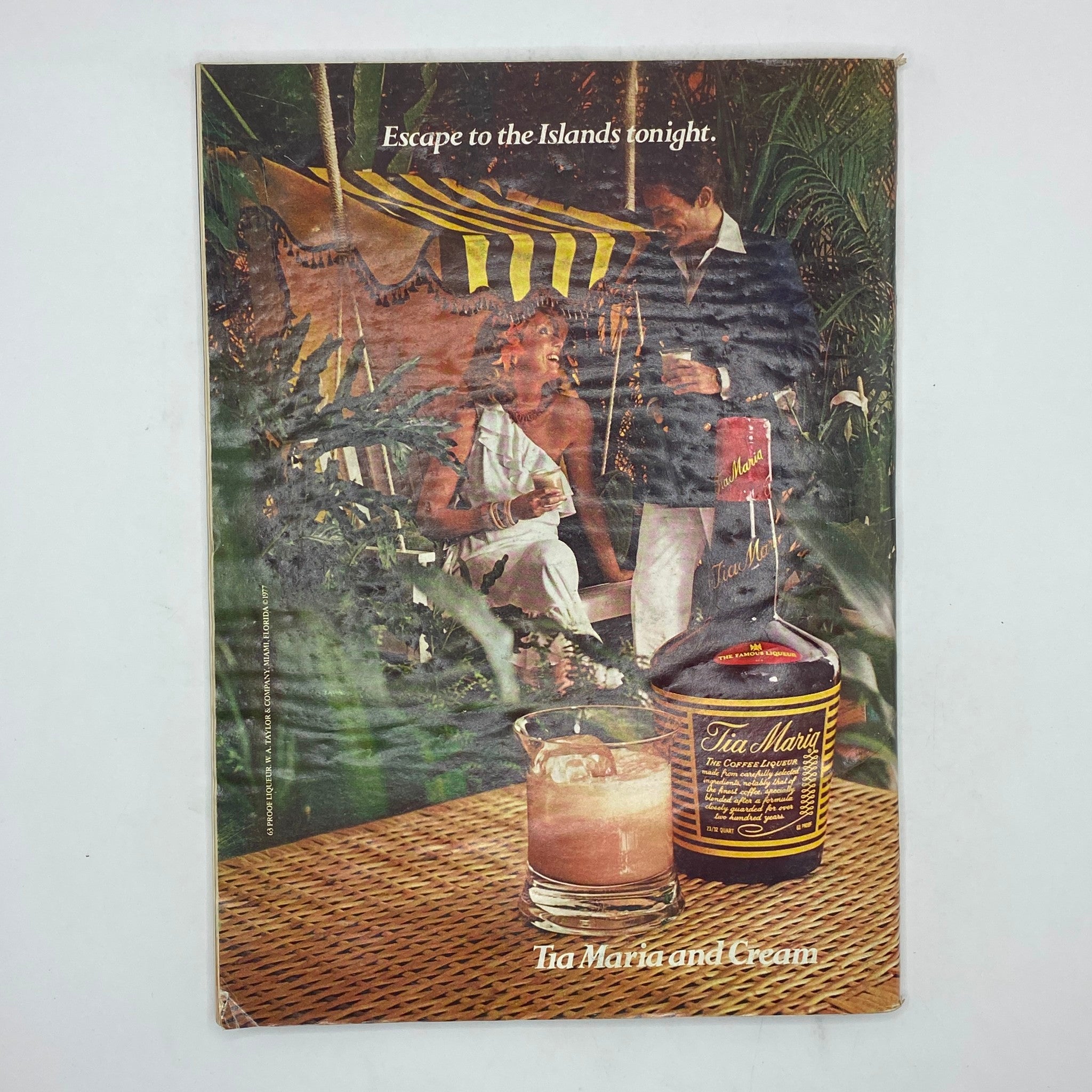 Back cover of The New Yorker magazine, December 5, 1977, featuring an advertisement for Tia Maria. The image depicts a tropical scene with a couple enjoying drinks, capturing the essence of leisure and escape.