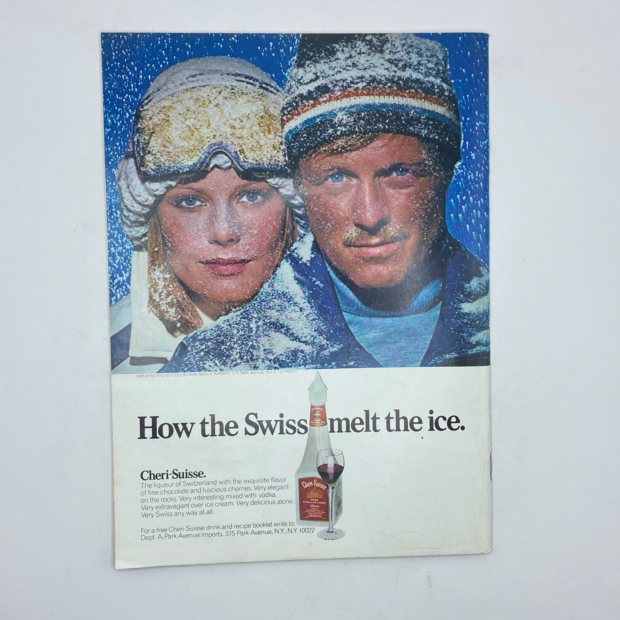 Ad page from The New Yorker Complete Magazine January 24, 1977, featuring a promotional advertisement for Cheri-Suisse liqueur, showcasing two models in winter attire.