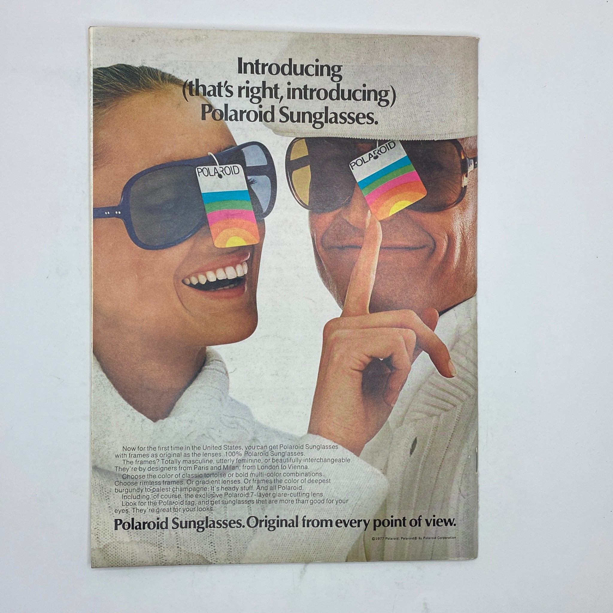 Vintage advertisement introducing Polaroid Sunglasses, showcasing a couple wearing stylish sunglasses, with text promoting the original design and interchangeable features.