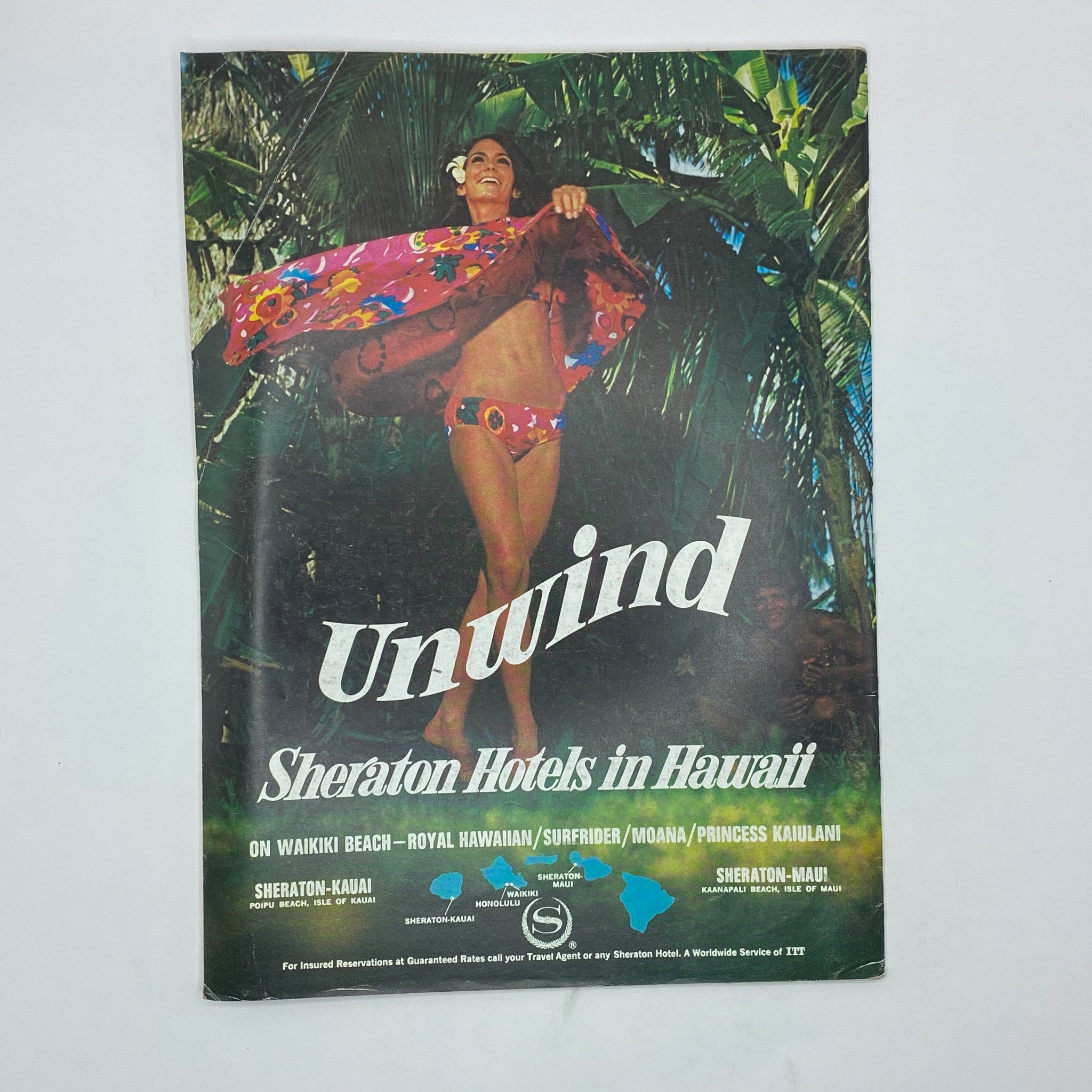 Vintage promotional magazine cover for Sheraton Hotels in Hawaii, featuring a woman in a floral swimsuit and wrap, with text 'Unwind' creatively displayed.