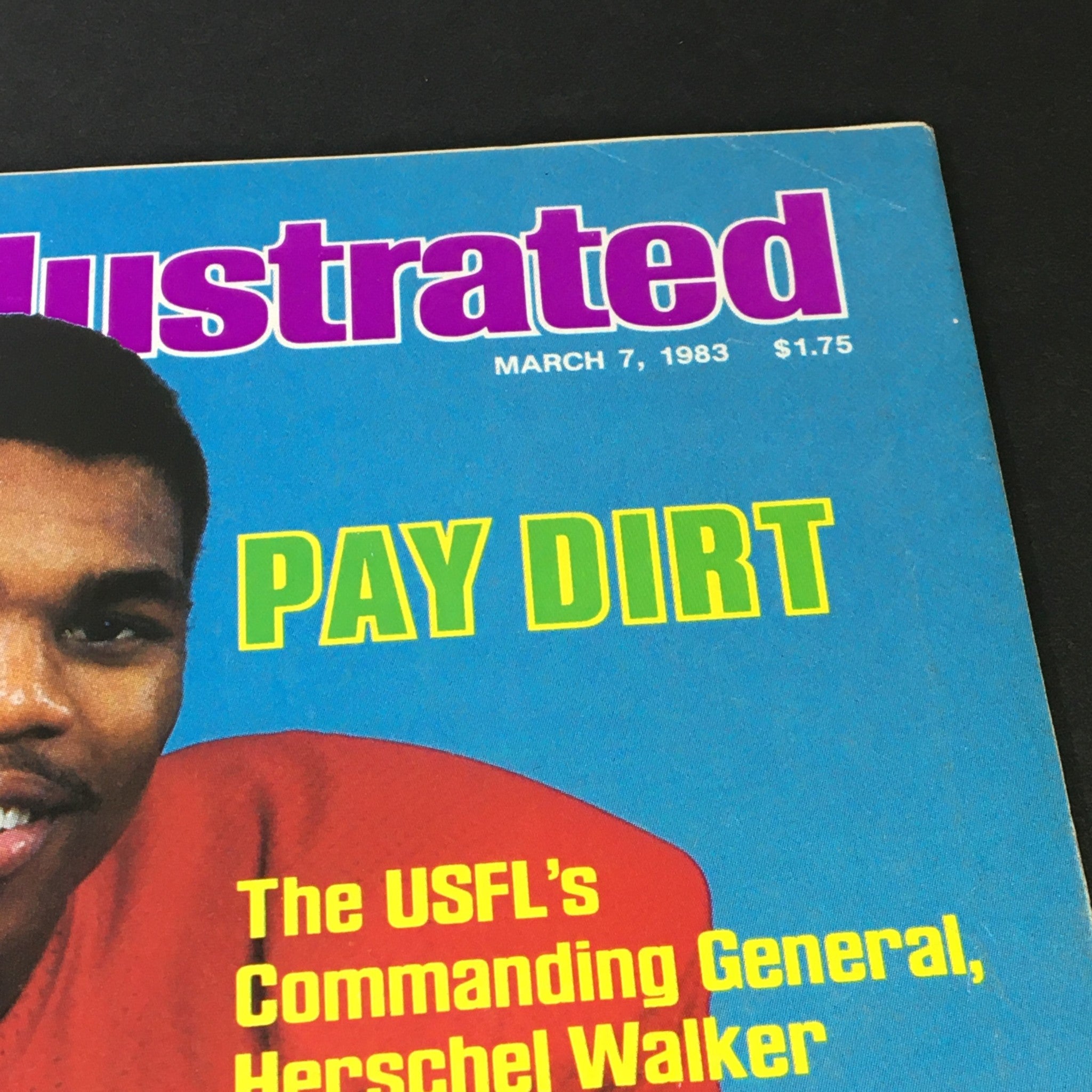 Close-up of the March 7, 1983, issue of Sports Illustrated magazine highlighting USFL's General Herschel Walker, emphasizing the title 'PAY DIRT' alongside his image.
