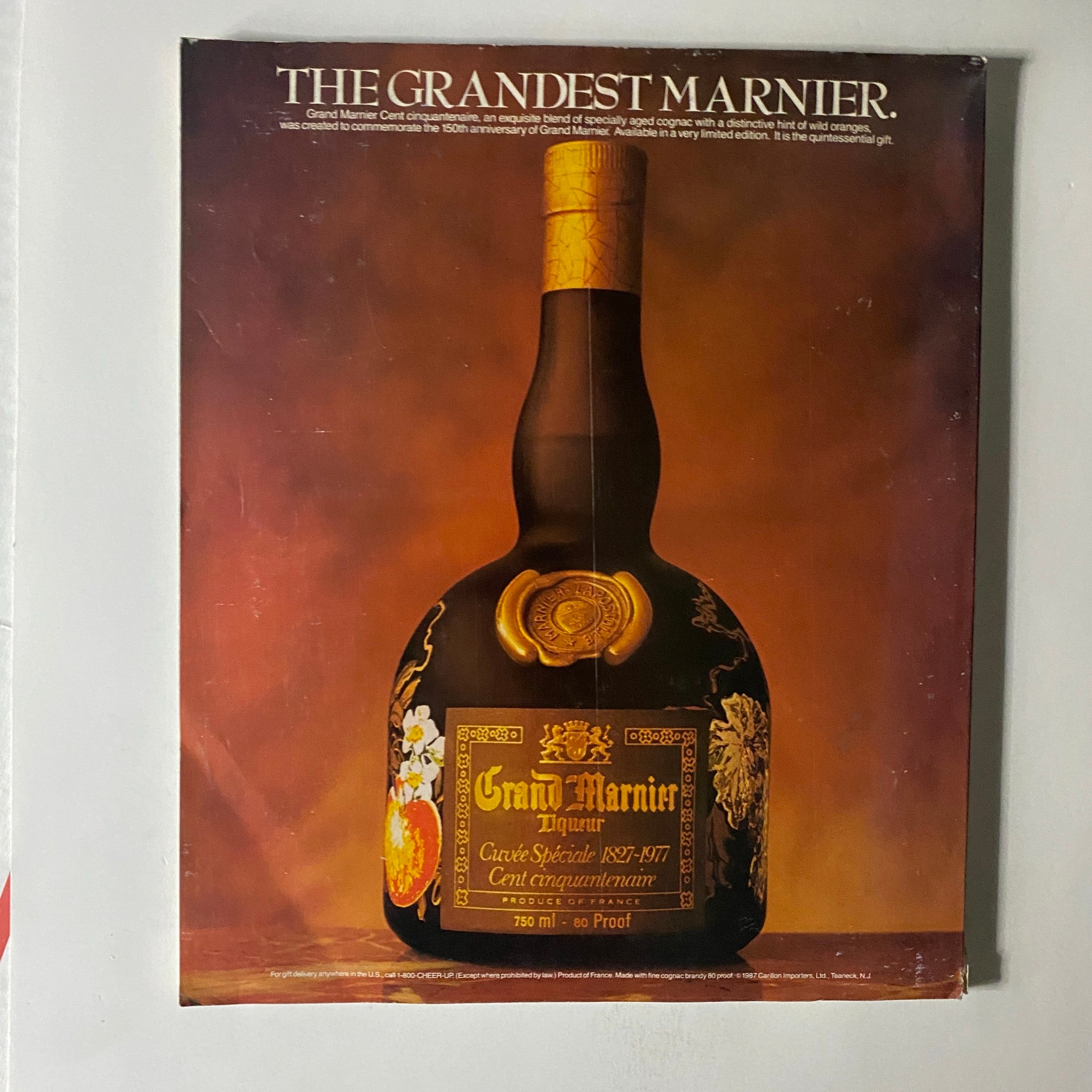 Vintage advertisement for Grand Marnier, with a focus on its special blend commemorating the 150th anniversary, showcasing the bottle design and branding.