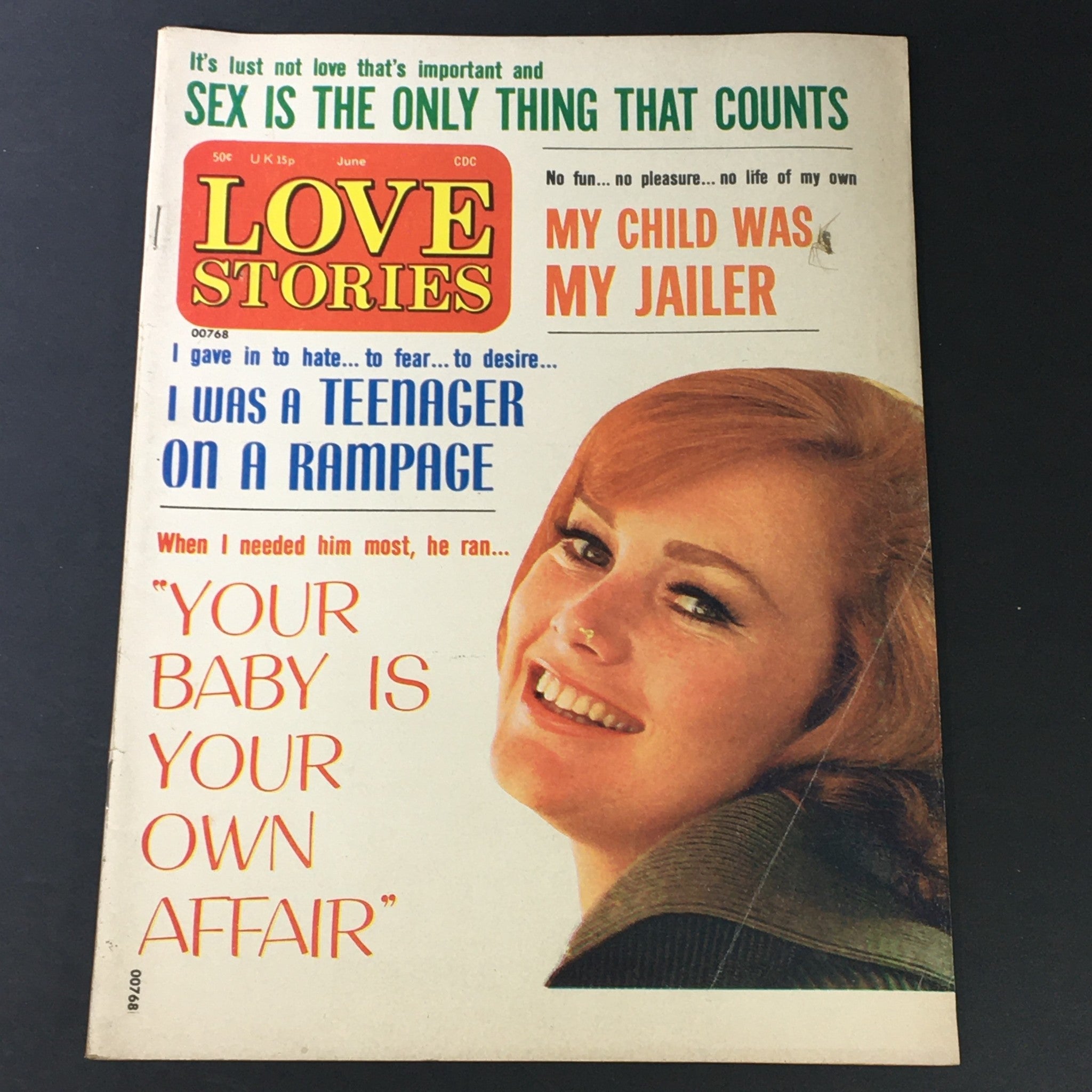 Front cover of VTG Love Stories Magazine June 1974 featuring the title 'My Child Was A Jailer', with illustrations and a smiling woman, showcasing vintage magazine aesthetics.