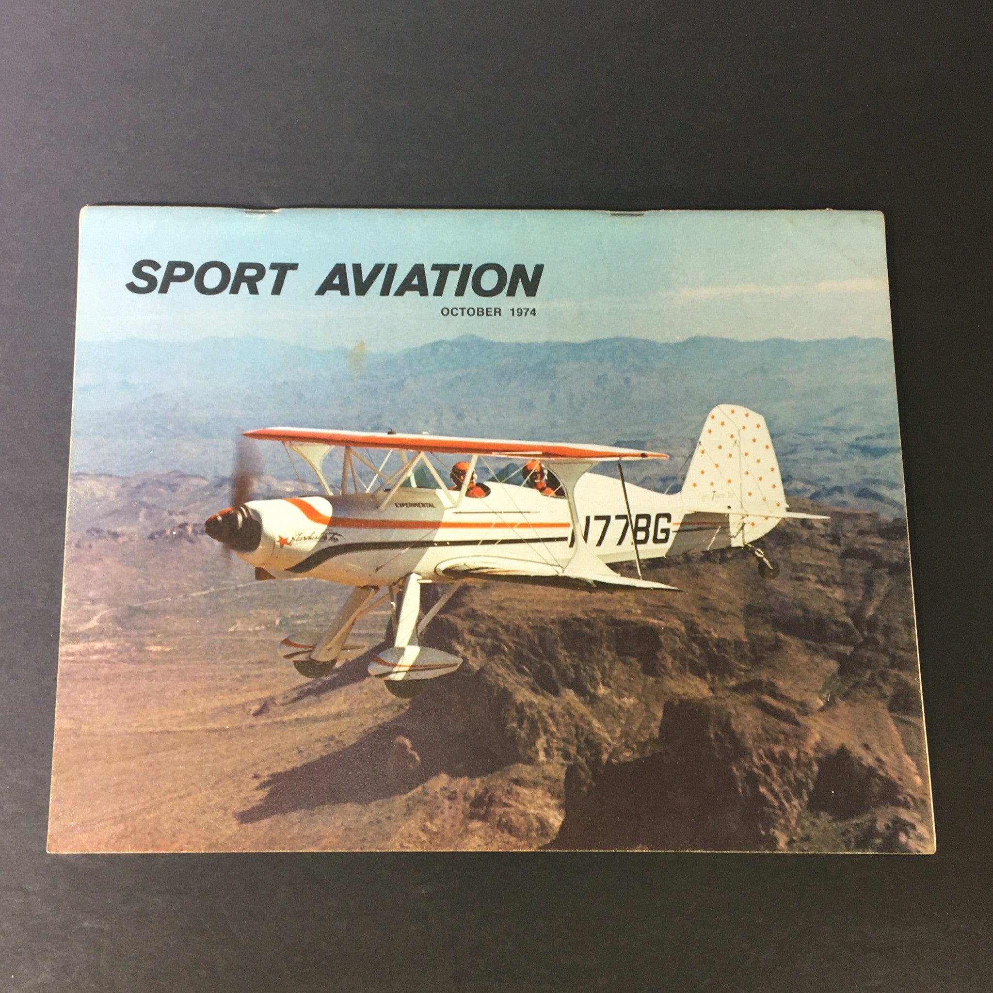 Cover of the 'Vintage Sport Aviation Magazine' from October 1974, featuring an aerobatic aircraft in flight against a mountainous backdrop, showcasing sport aviation history.