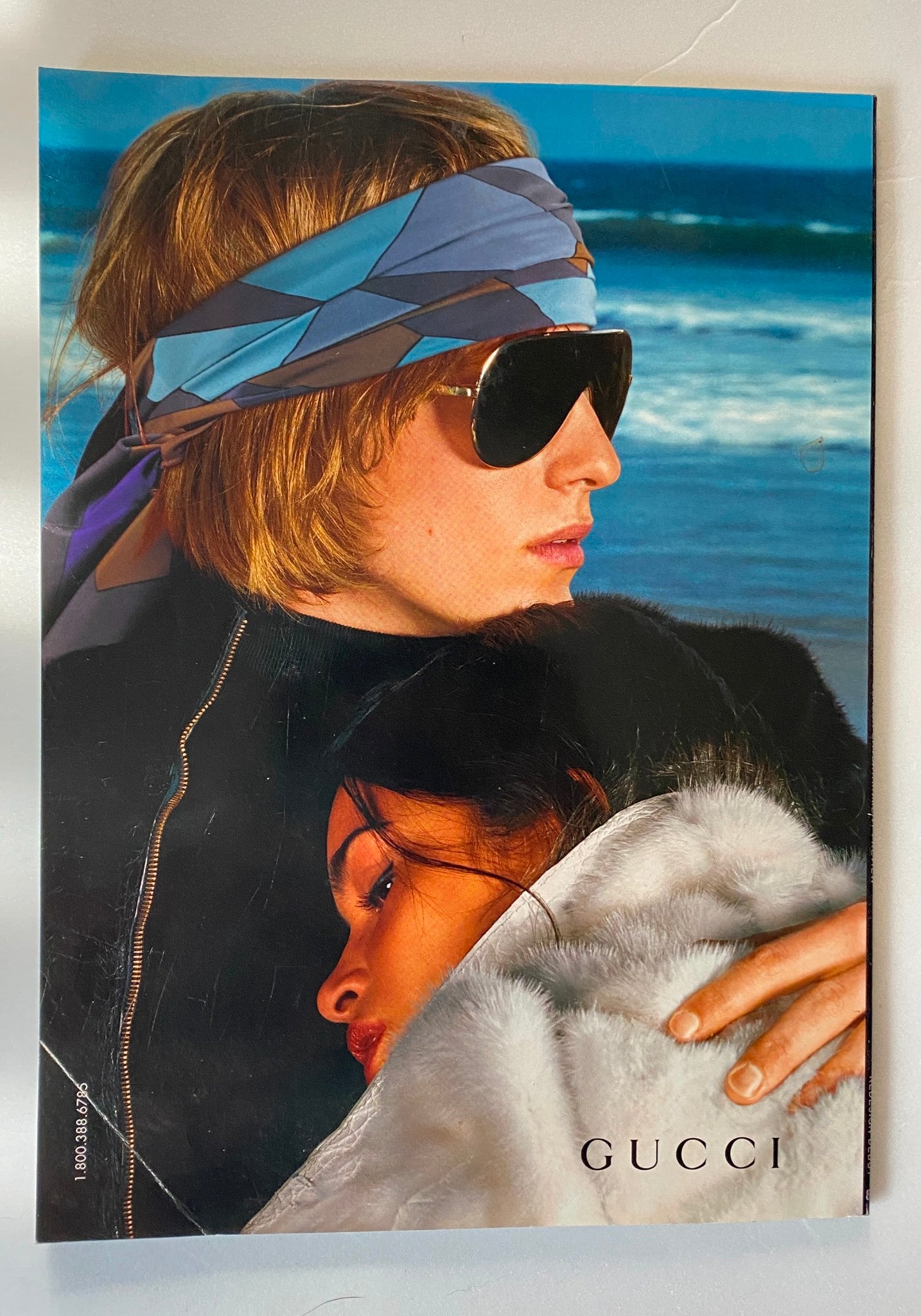 Gucci advertisement from Out Magazine September 2000, featuring a model in sunglasses with a coastal backdrop, representing fashion aesthetics of the time.