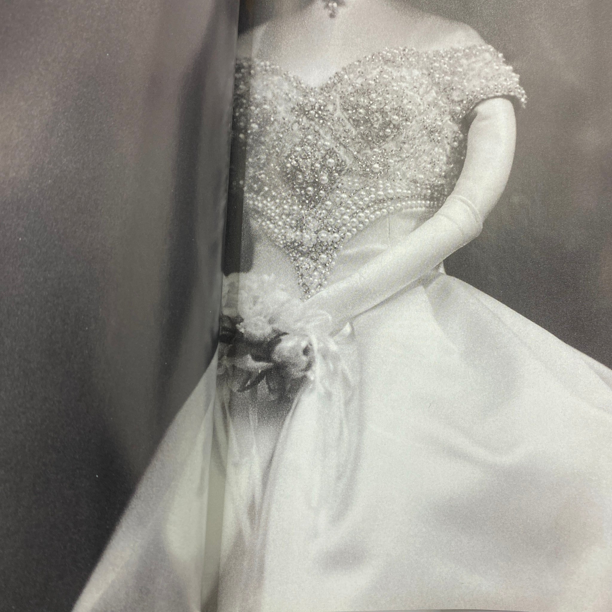 Black and white close-up image of a glamorous wedding dress featured in Detour Magazine March 1998, highlighting intricate pearl embellishments and classic elegance.