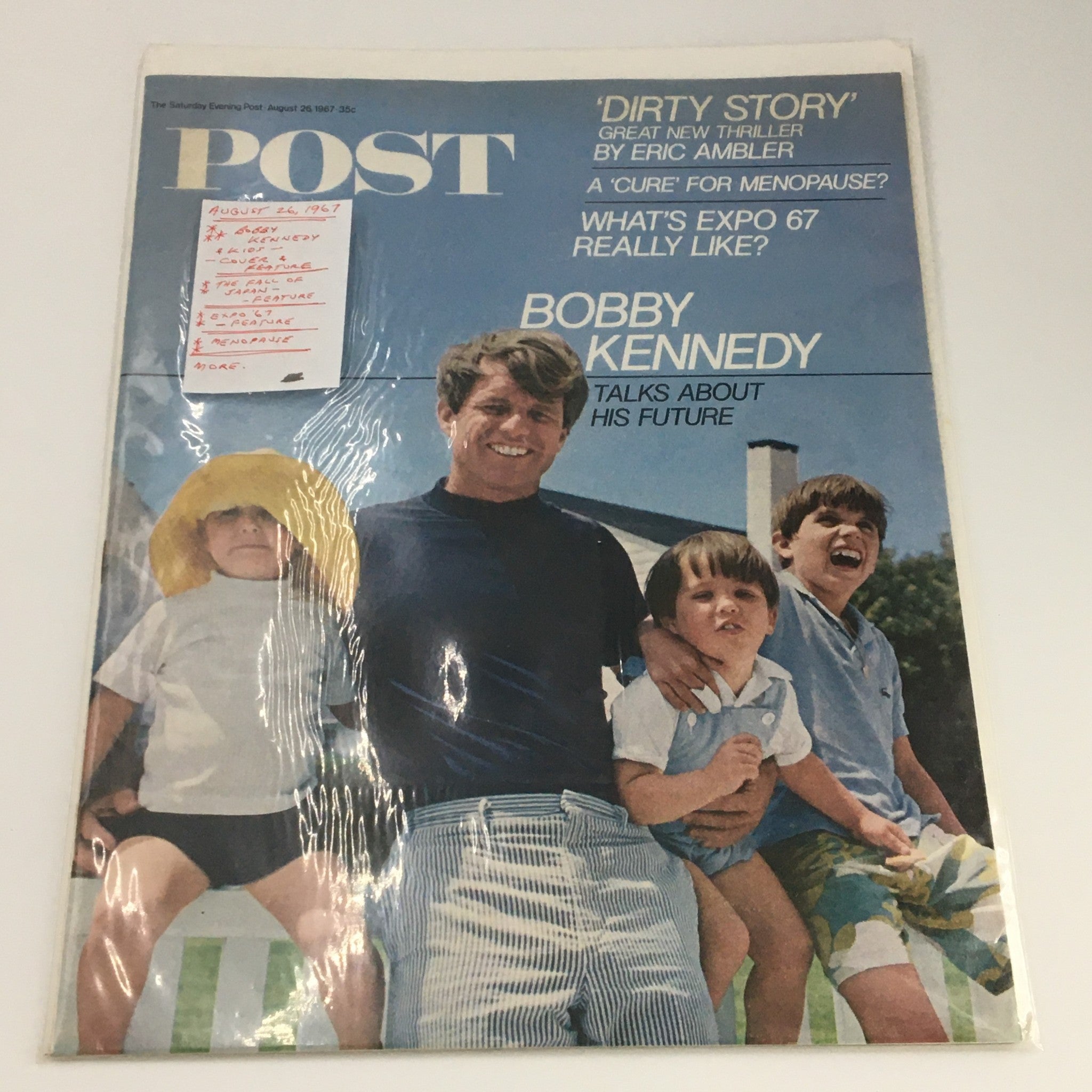 The Saturday Evening Post August 26 1967 cover preserved in protective plastic, displaying Bobby Kennedy with kids, an iconic representation of family and hope.