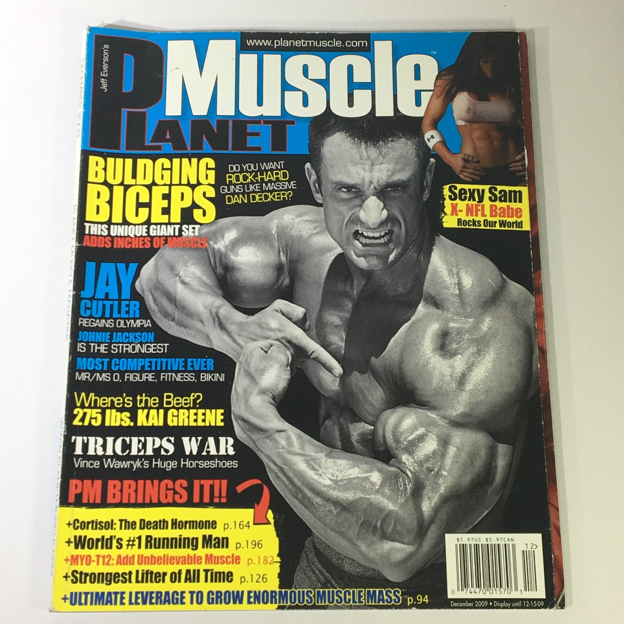 Cover of Planet Muscle Magazine December 2009 featuring Jay Cutler celebrating his victory at the Mr. Olympia title. The magazine highlights bodybuilding topics such as bulging biceps, triceps training, and includes articles about fitness and competition insights.