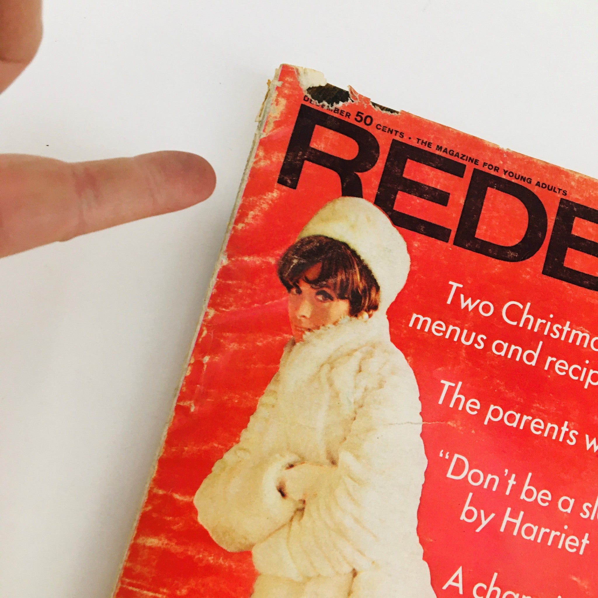 Close-up view of the cover of Redbook Magazine December 1967, showcasing the magazine's title and winter-themed content, with minor wear visible.