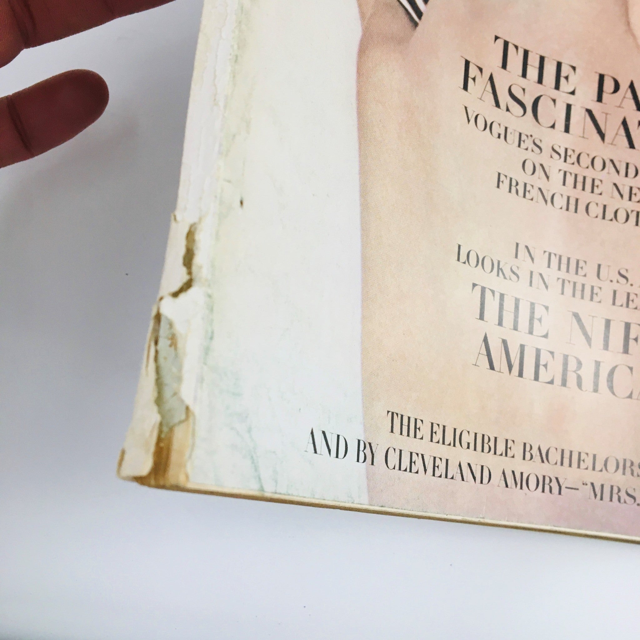 Detailed view of the back corner of Vogue Magazine September 15, 1964 showing signs of aging and wear, still maintaining the title 'The Paris Fascination'.