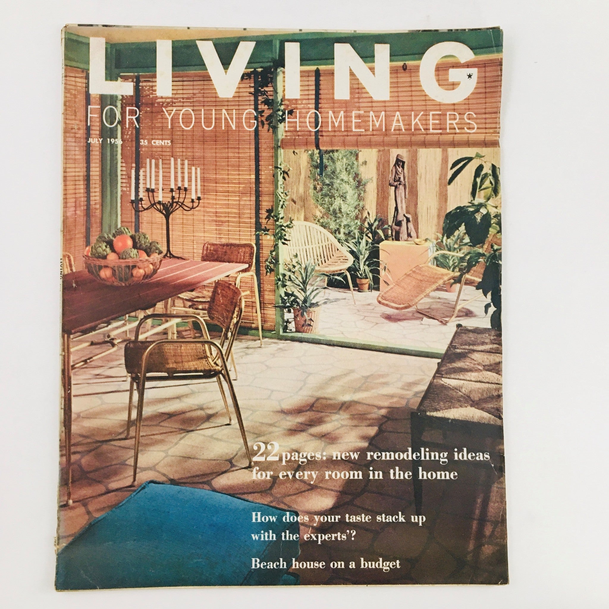 Cover of 'Living For Young Homemakers' July 1955 magazine, featuring a beach house design on a budget, showcasing a cozy indoor space with dining area and plants, highlighting remodeling ideas.