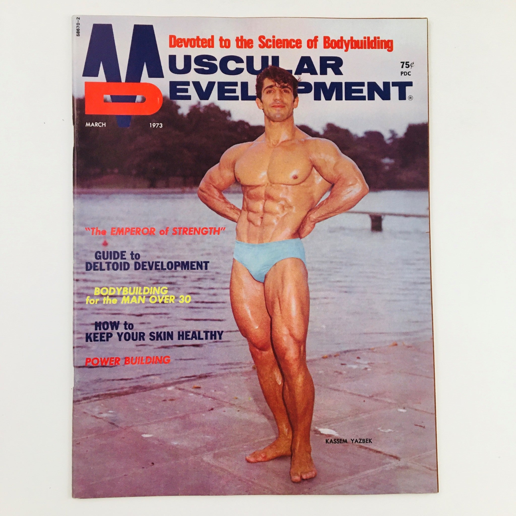 Cover of Muscular Development Magazine March 1973 featuring Kassem Yazbek in a bodybuilding pose, highlighting his physique and the magazine's focus on fitness culture.